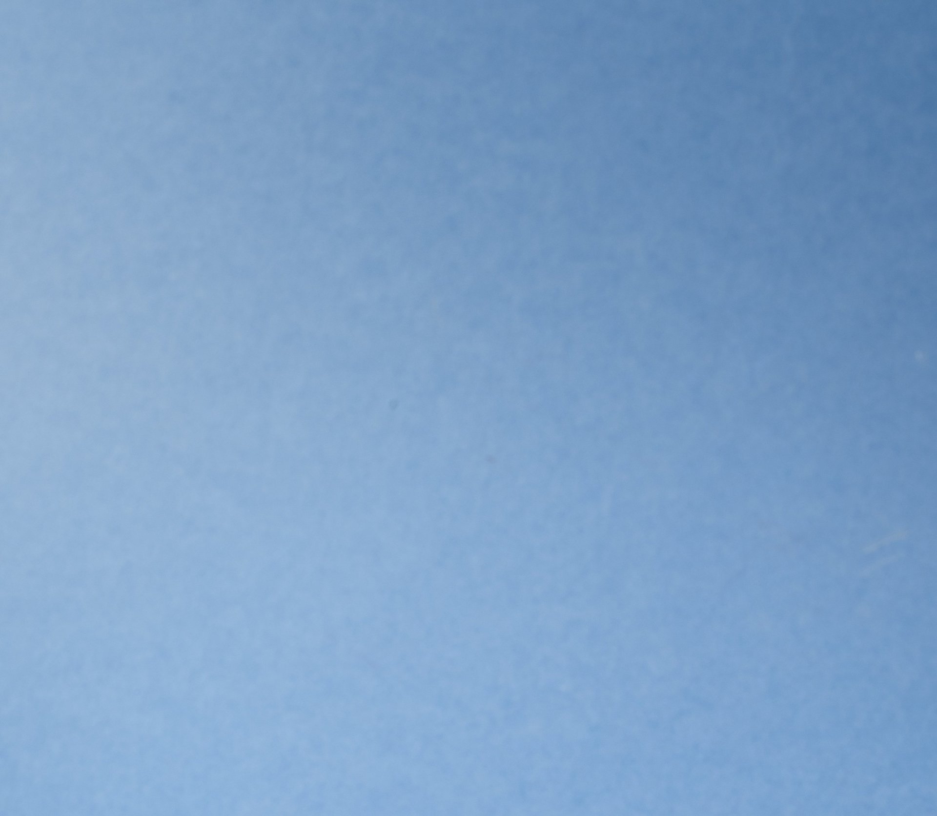 an abstract photo of a curved building with a blue sky in the background