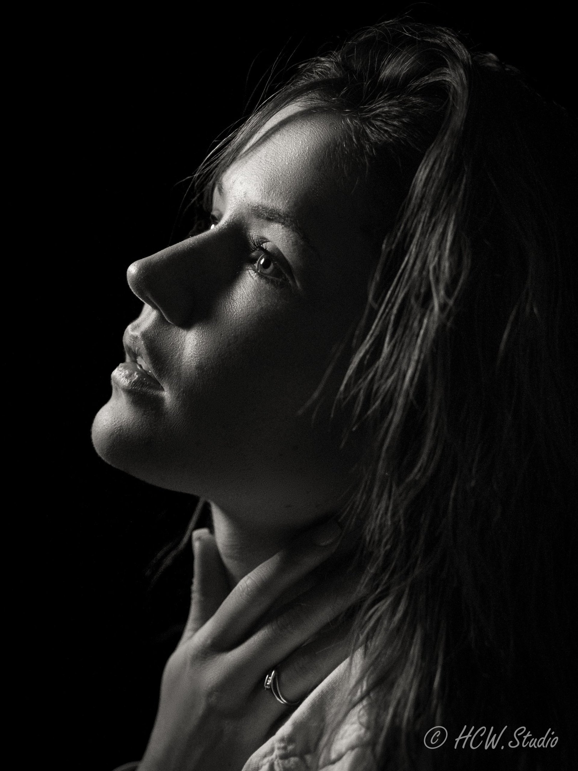braided woman taking photo beside yellow painted wall