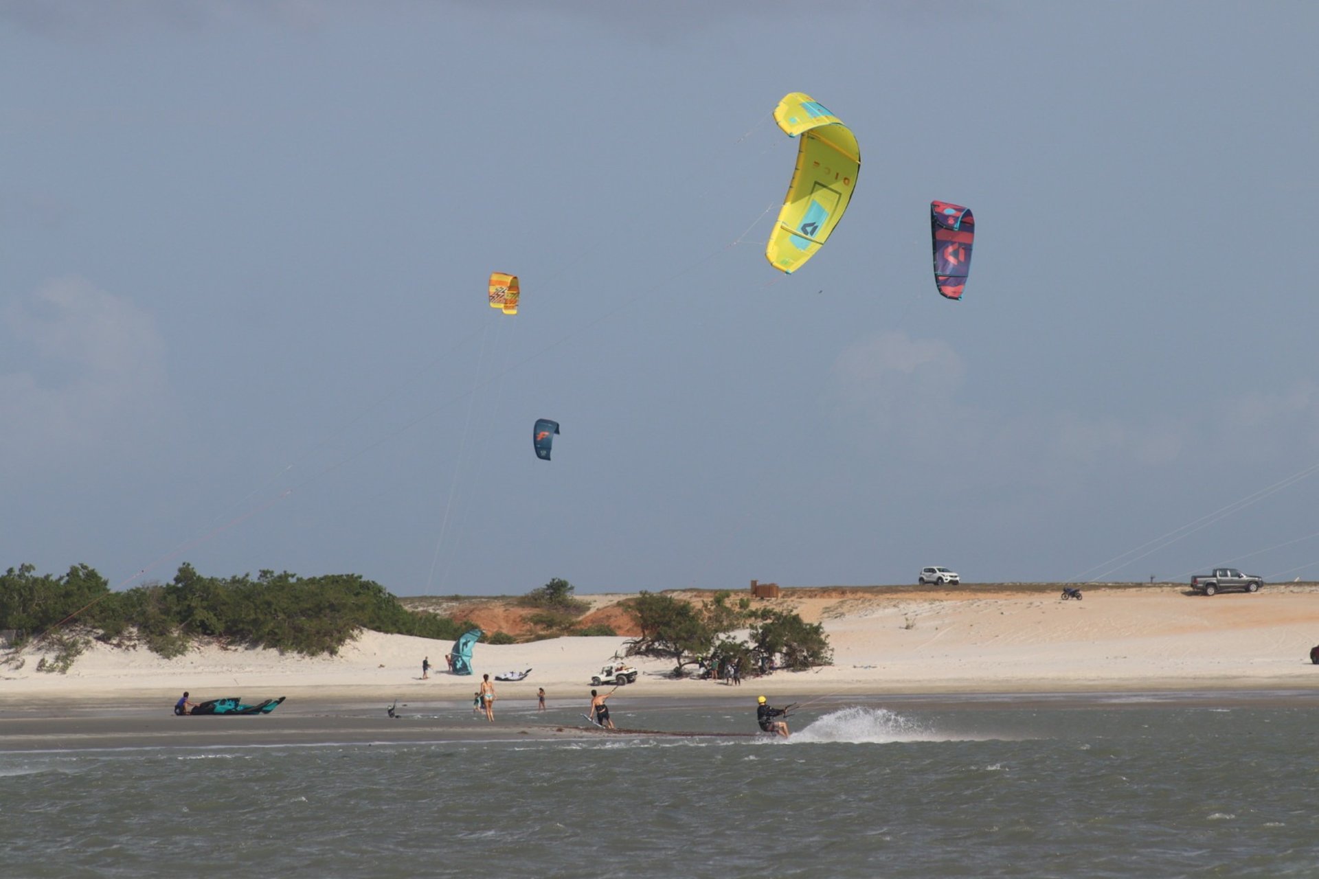a group of people standing on top of a sandy beach