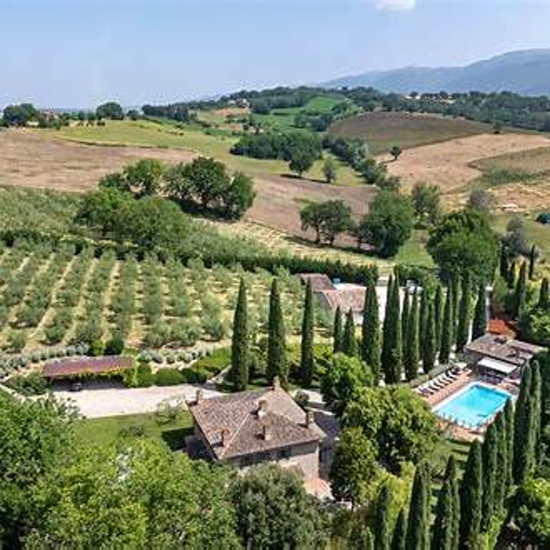 Four chairs by a pool overlooking rolling hills