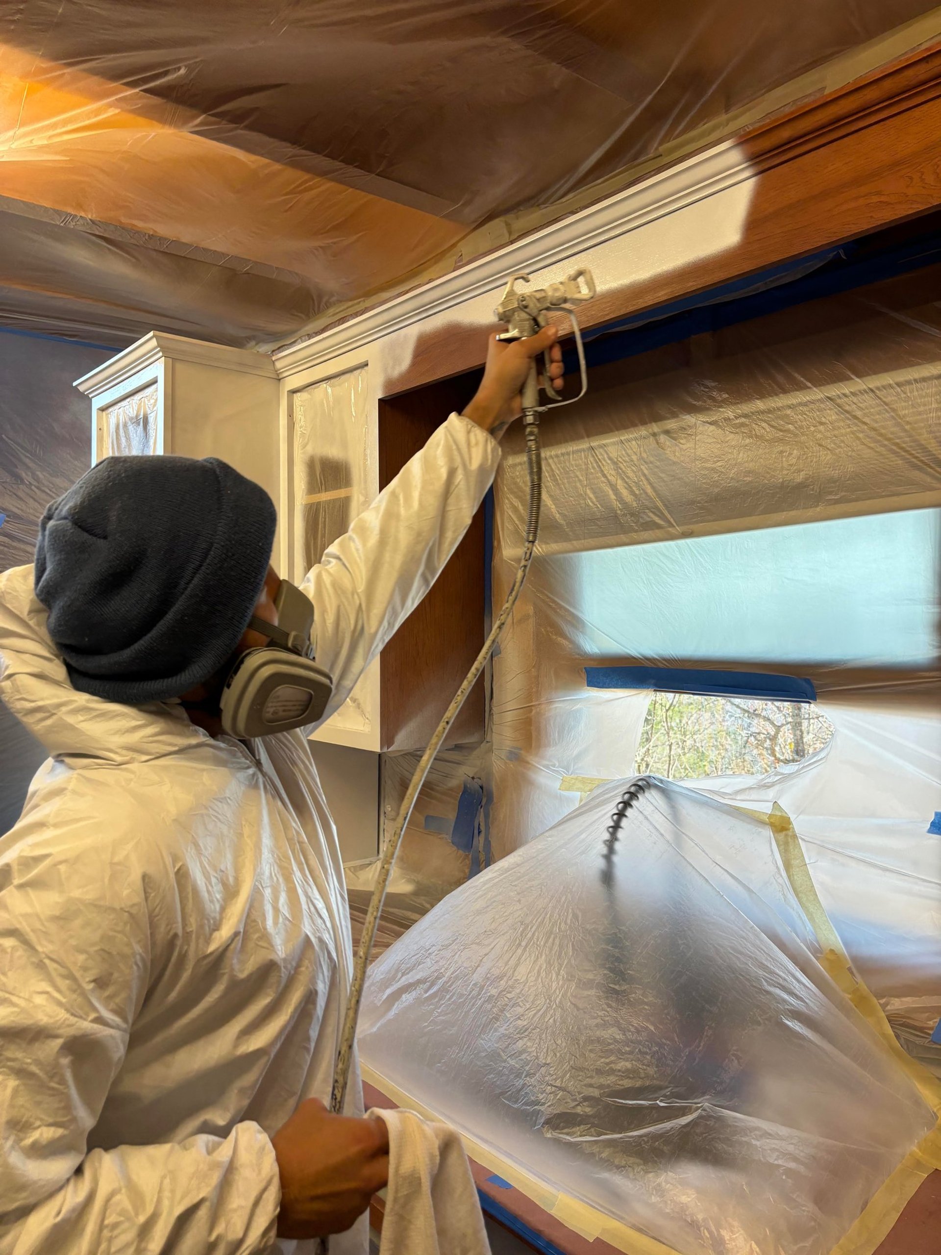 Passion Painters employee spraying kitchen cabinet frame in Sylva, NC