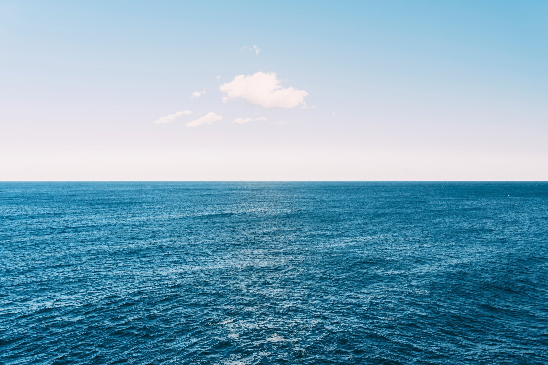 body of water under blue and white sky at daytime