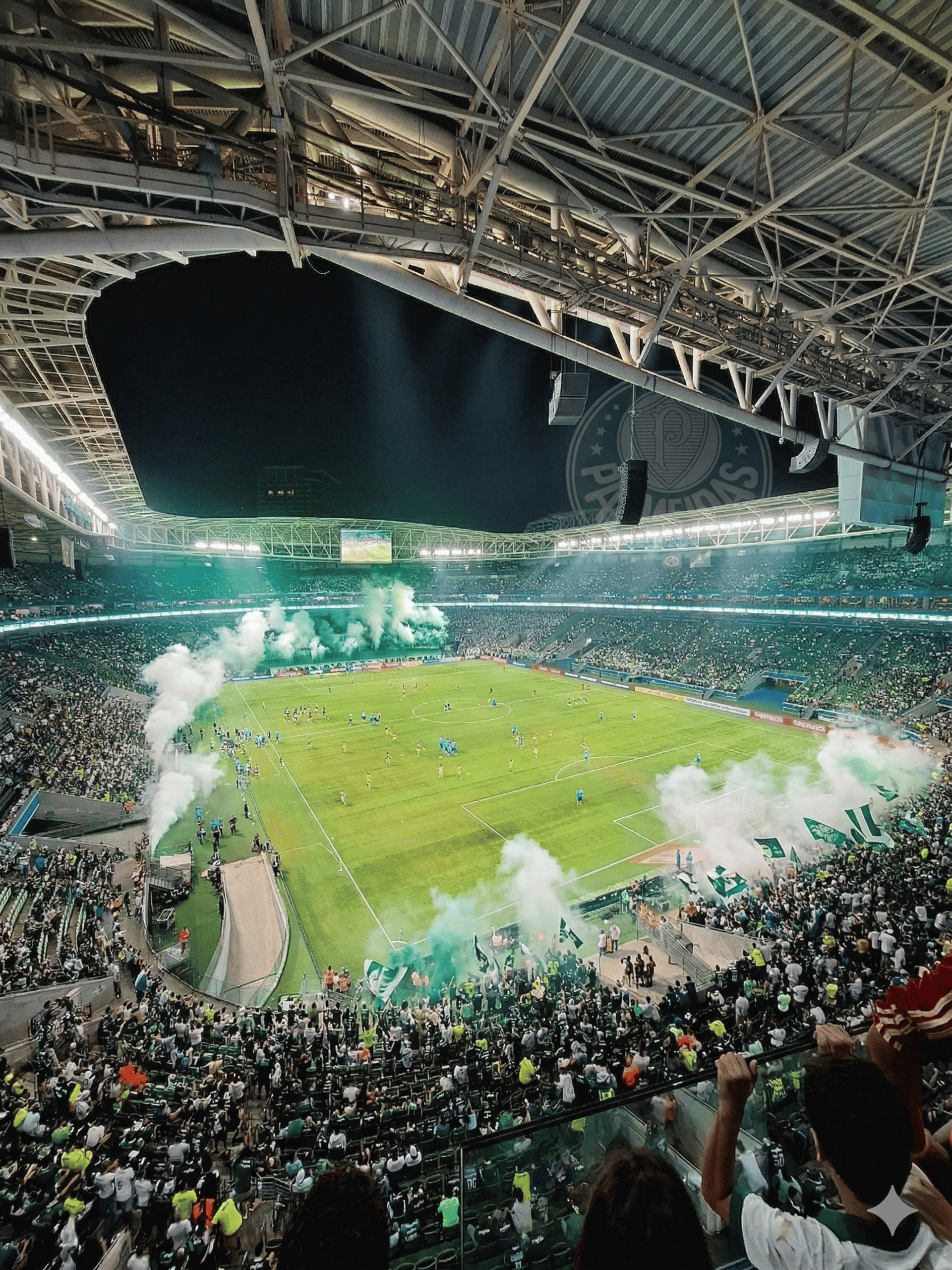 Vista panorâmica aérea do Allianz Parque em noite de jogo, destacando a torcida Alviverde vibrando e fumaça verde.