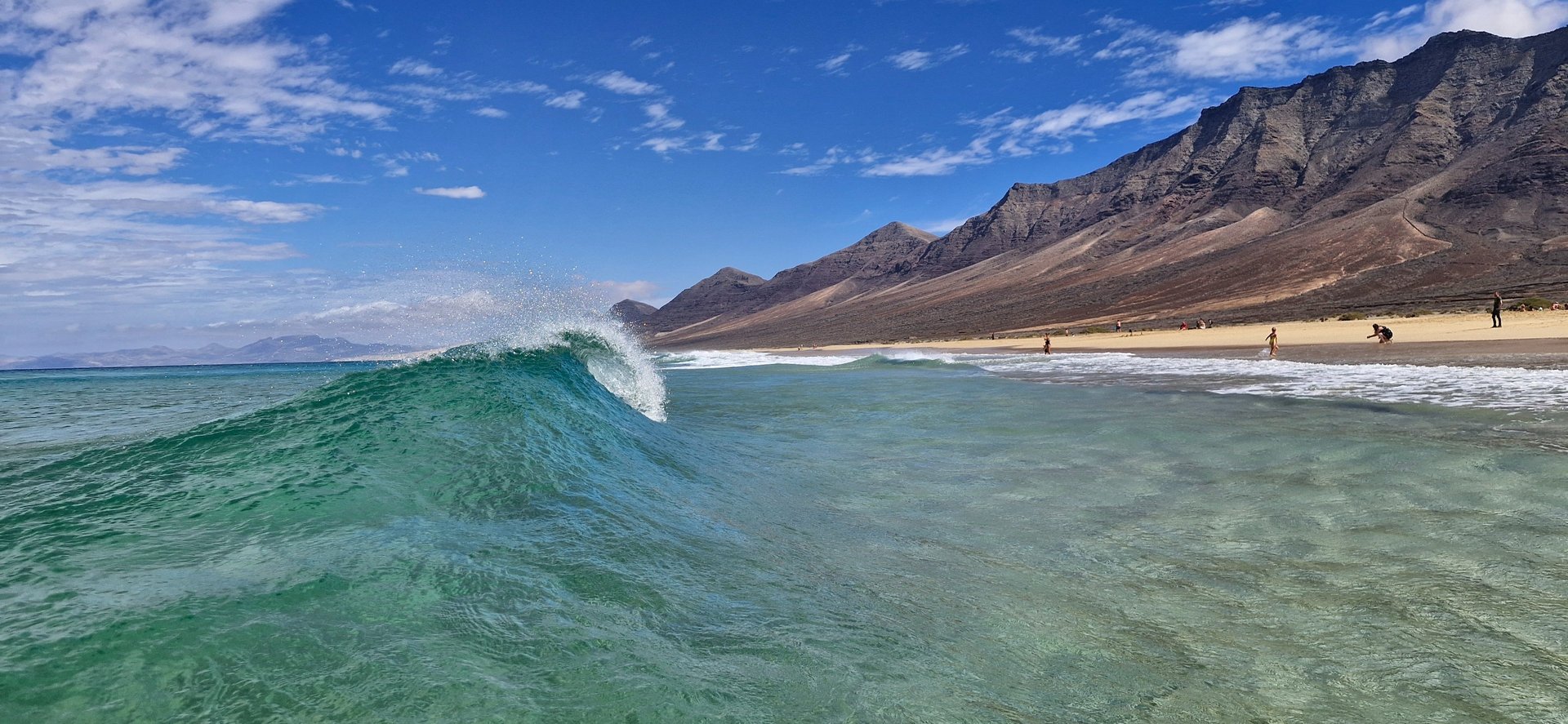 woman wearing yellow long-sleeved dress under white clouds and blue sky during daytime