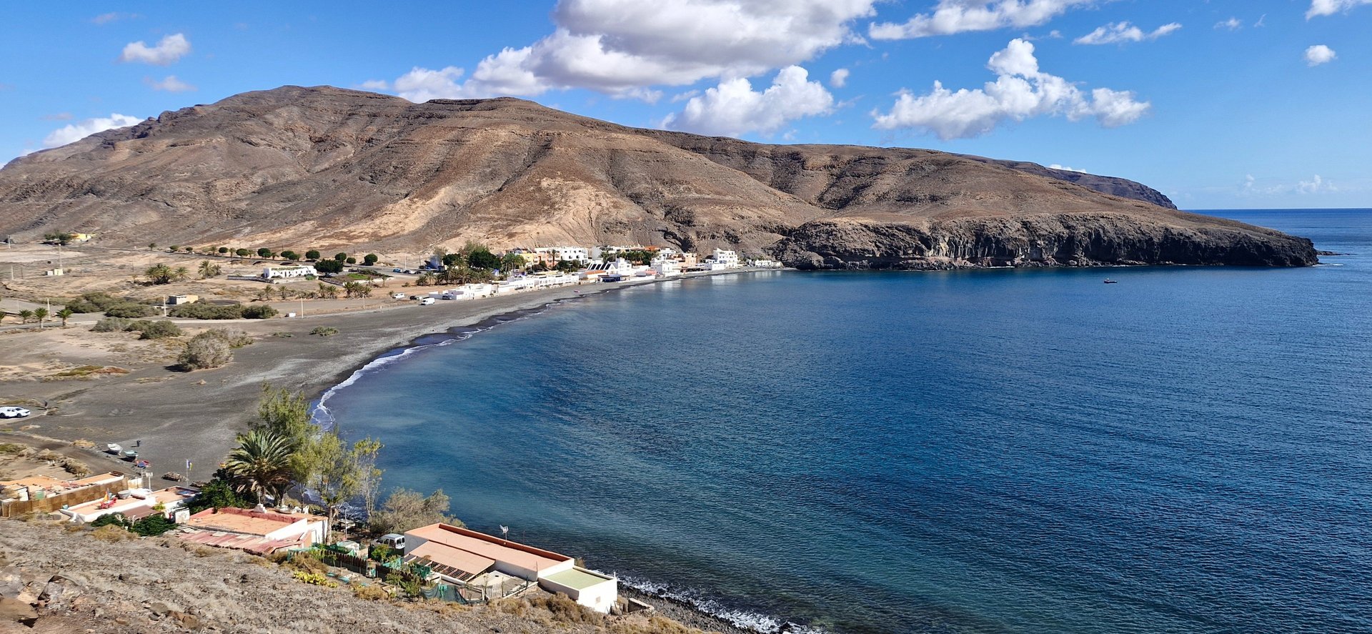 woman wearing yellow long-sleeved dress under white clouds and blue sky during daytime