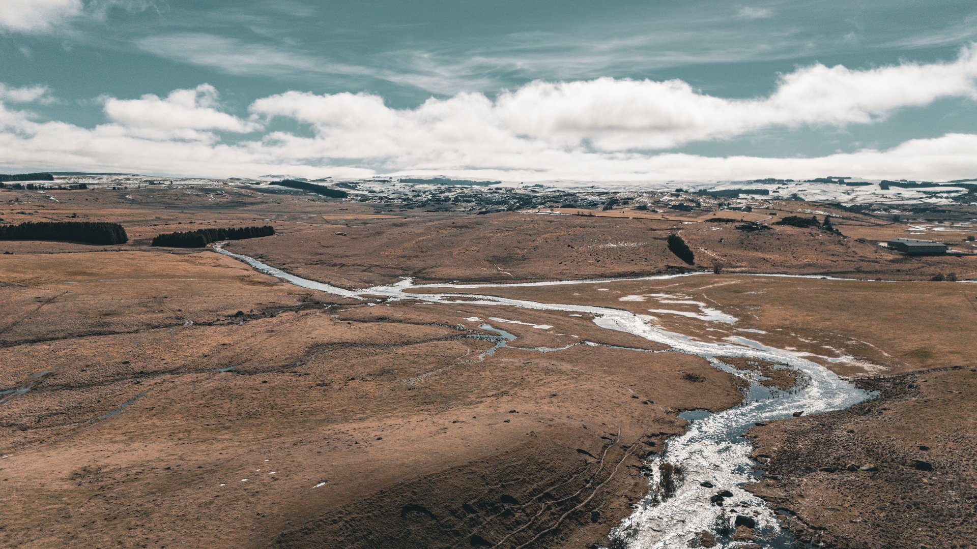 a grassy hill with a fence