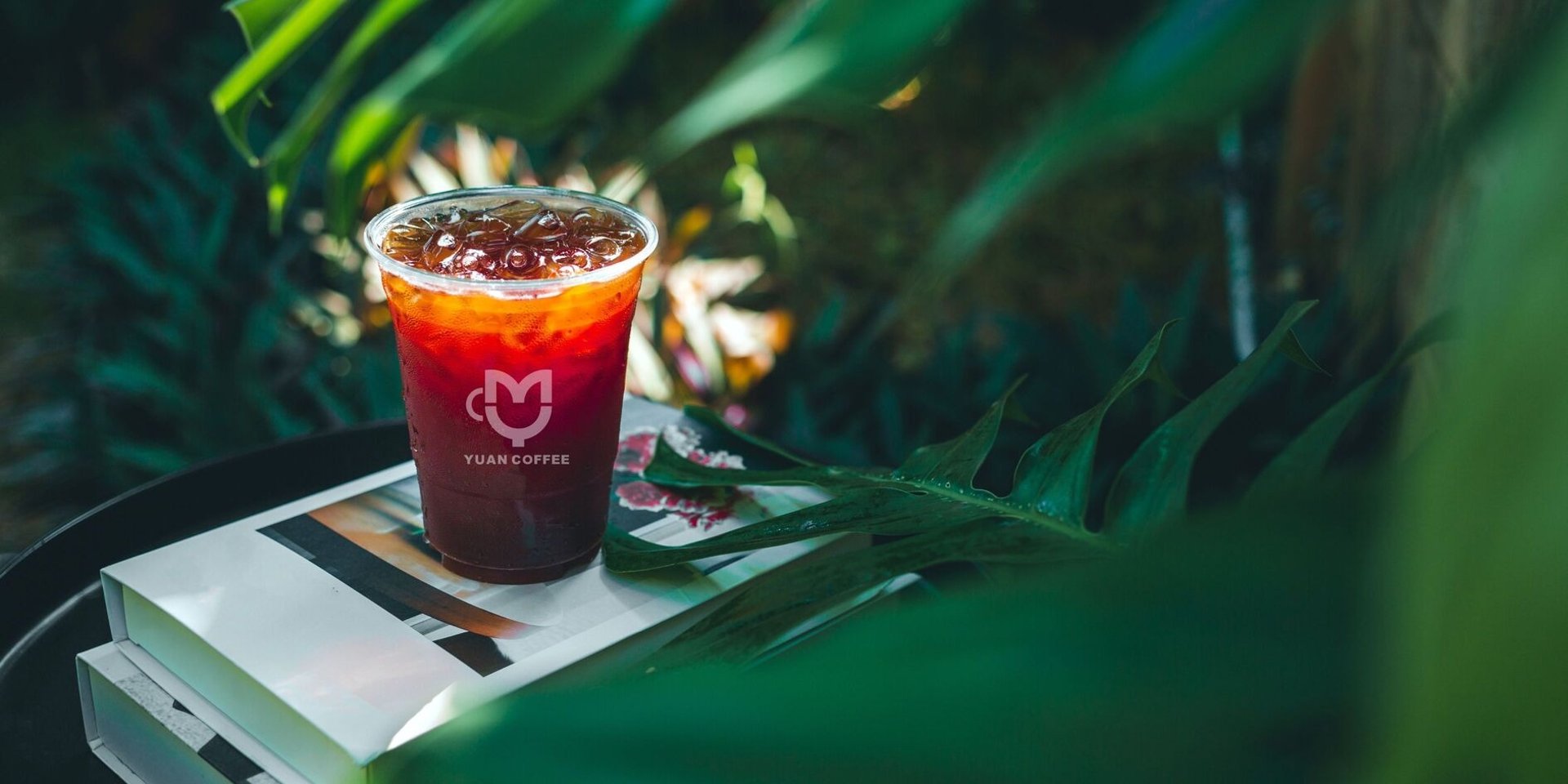 clear drinking glass with coffee on top of white table