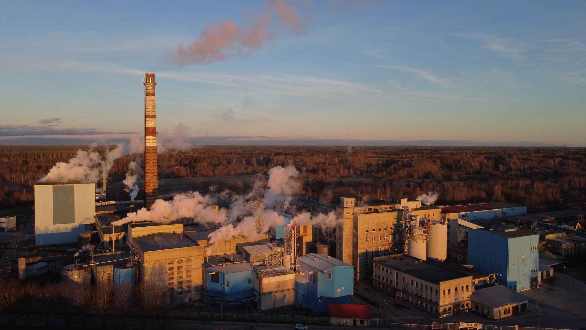 lighted brown concrete buildings near body of water at nighttime