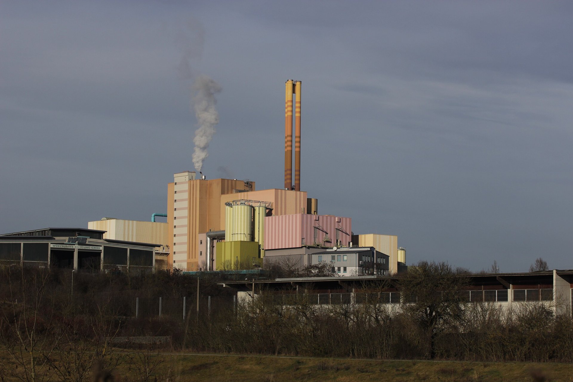 lighted brown concrete buildings near body of water at nighttime