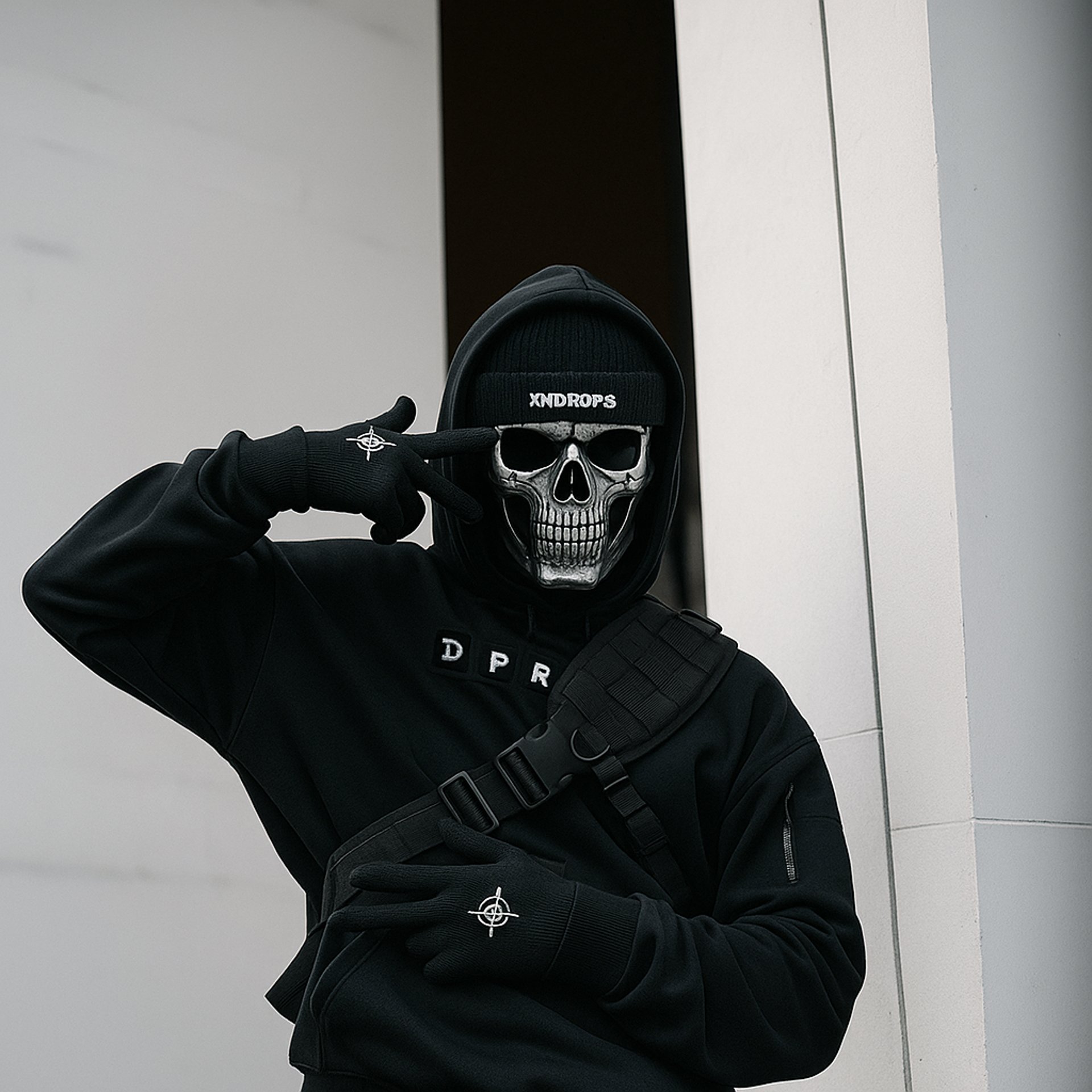 woman in hoodie standing in front of white wall