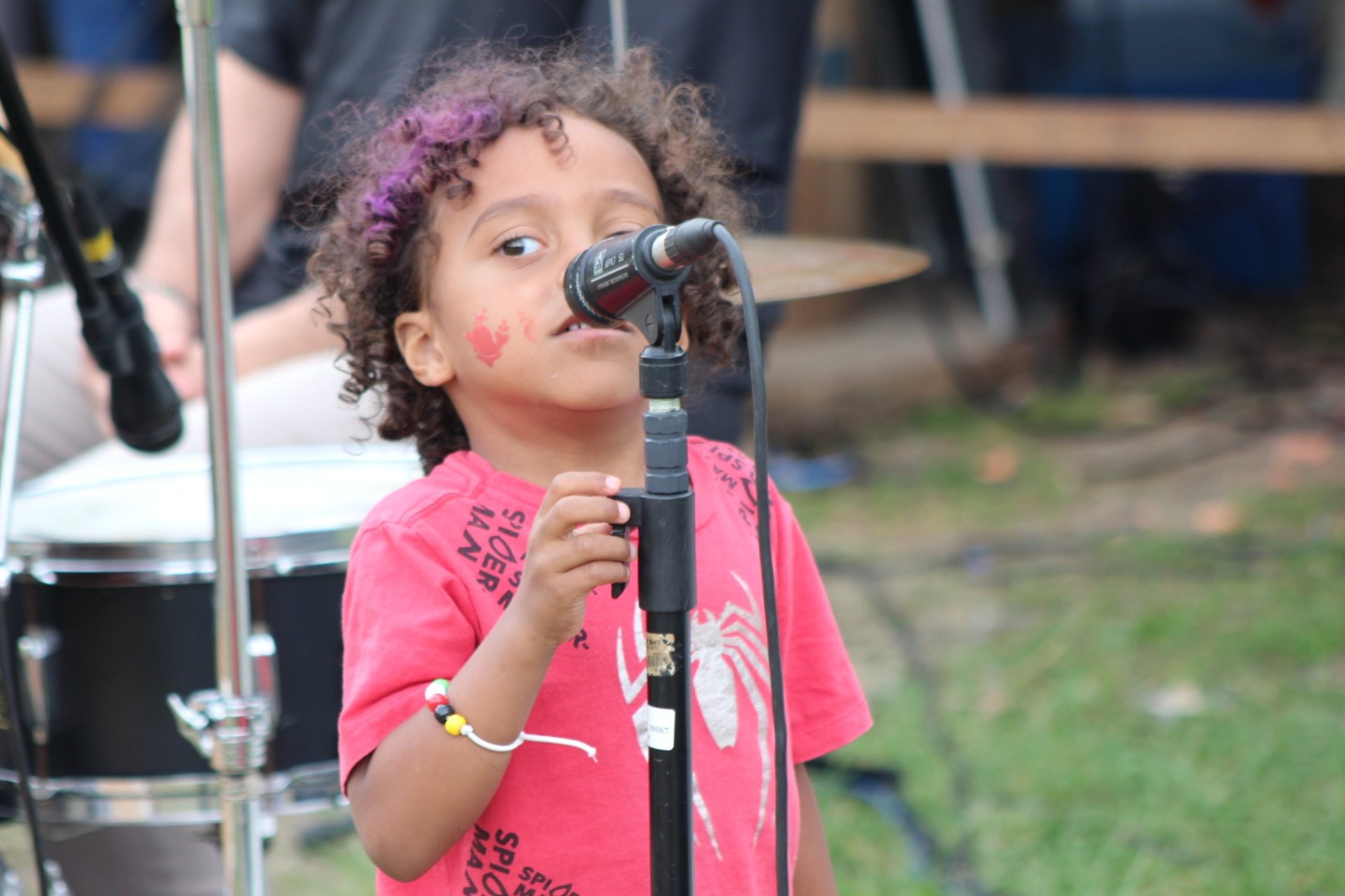 girl in pink tank top standing beside girl in blue and red dress