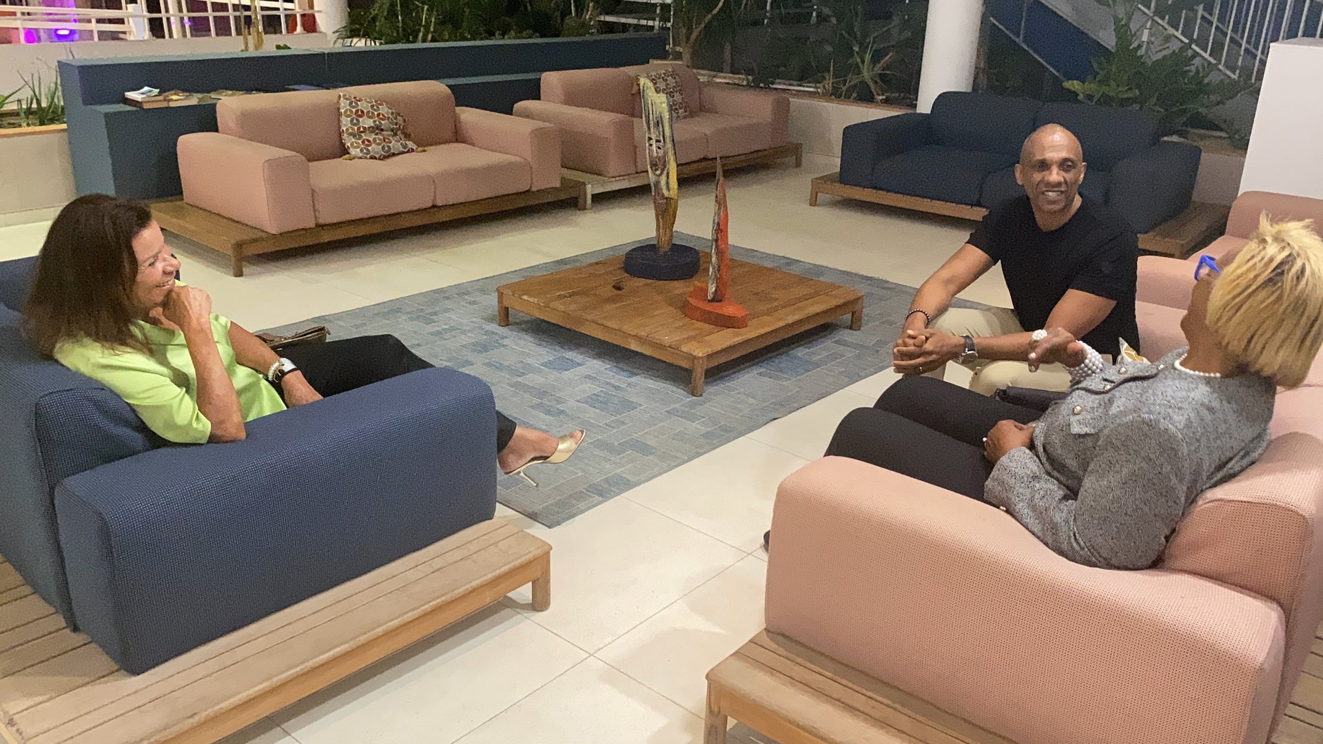 Bruno Valery en discussion avec deux porteurs de projet dans le hall d’un hôtel de luxe en Guadeloupe, échange stratégique su