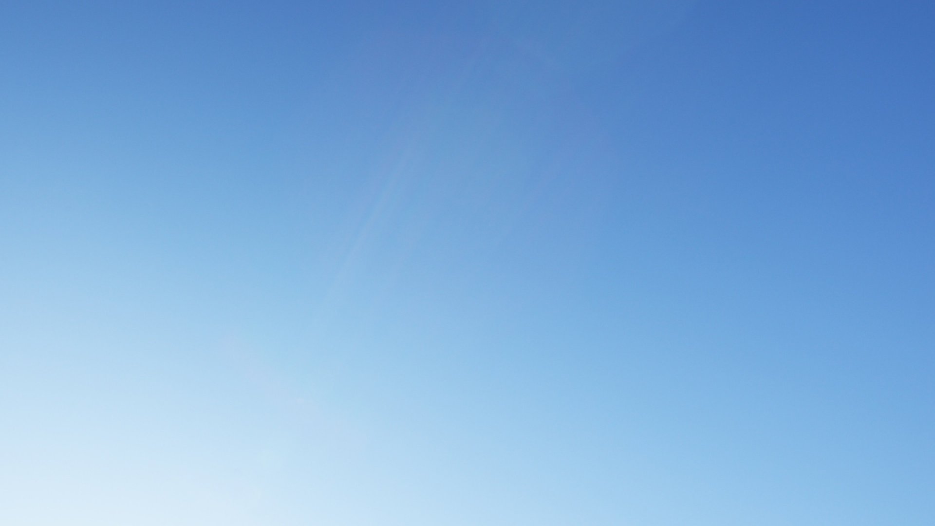 an abstract photo of a curved building with a blue sky in the background
