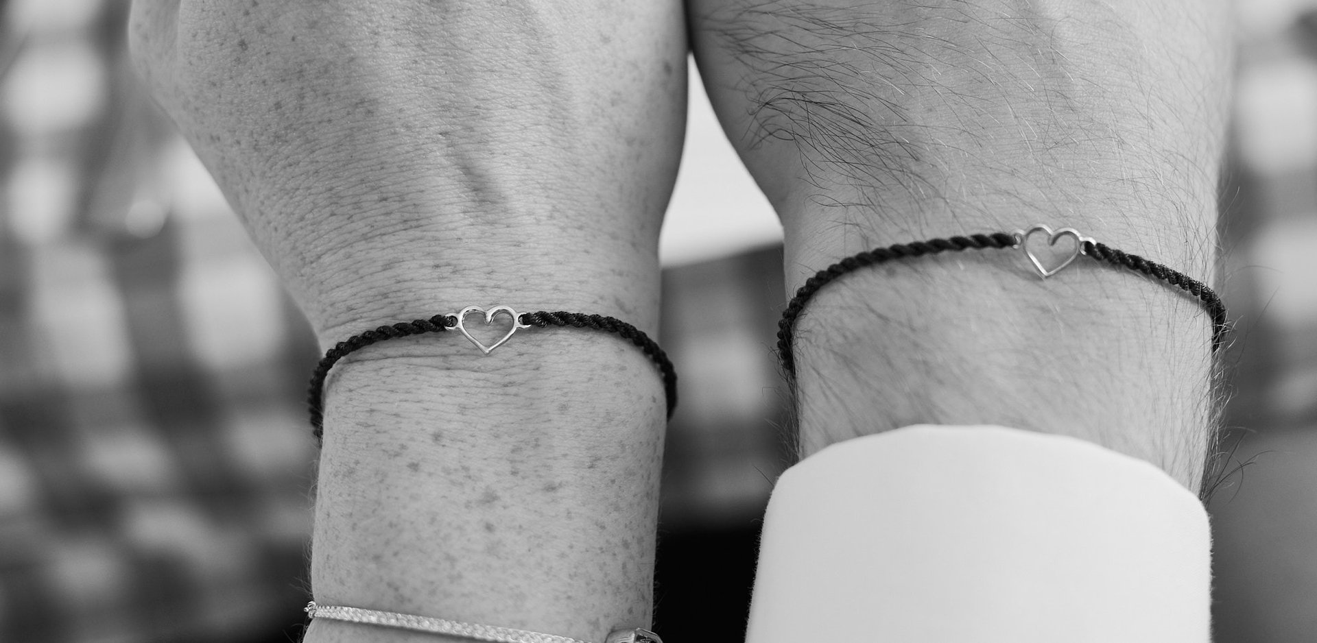 Armbands with a heart shaped charm on the hands of newlyweds. 