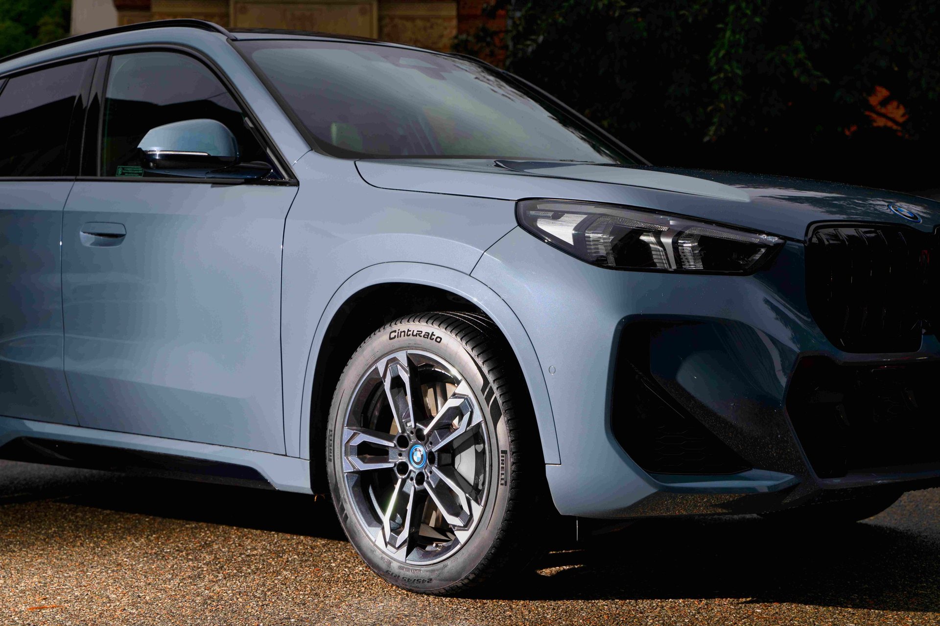 man in white shirt standing beside black car