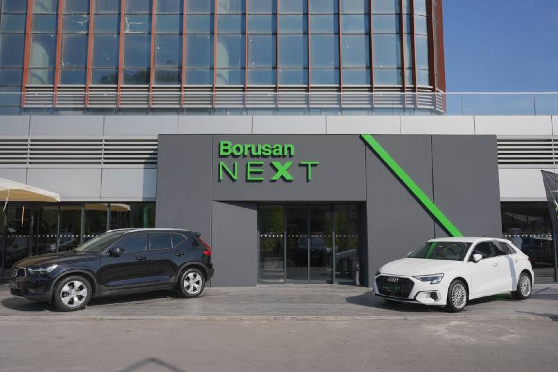 man in white shirt standing beside black car
