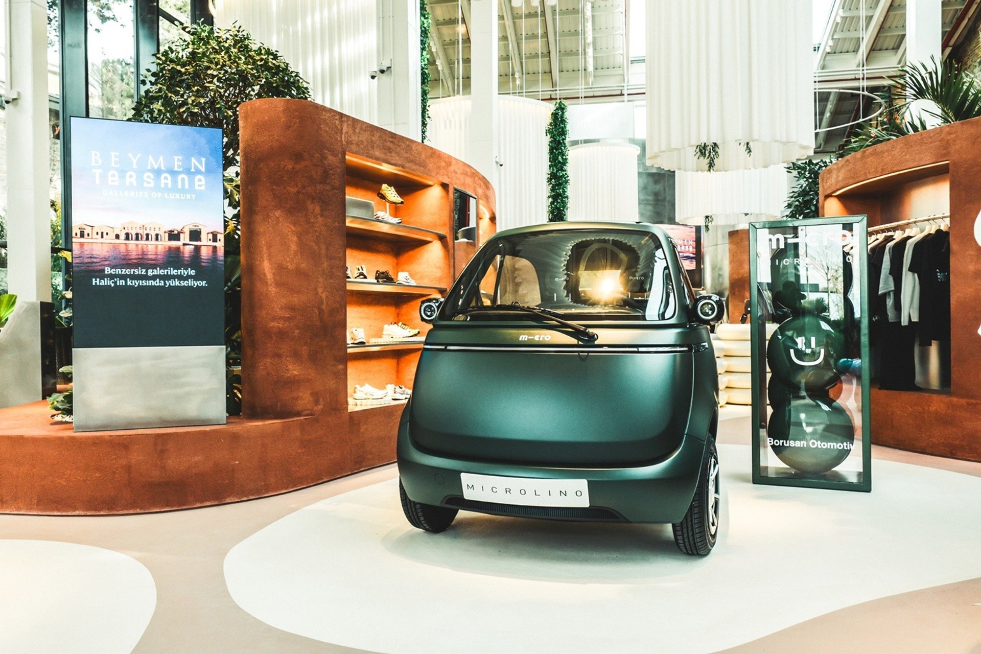 man in white shirt standing beside black car