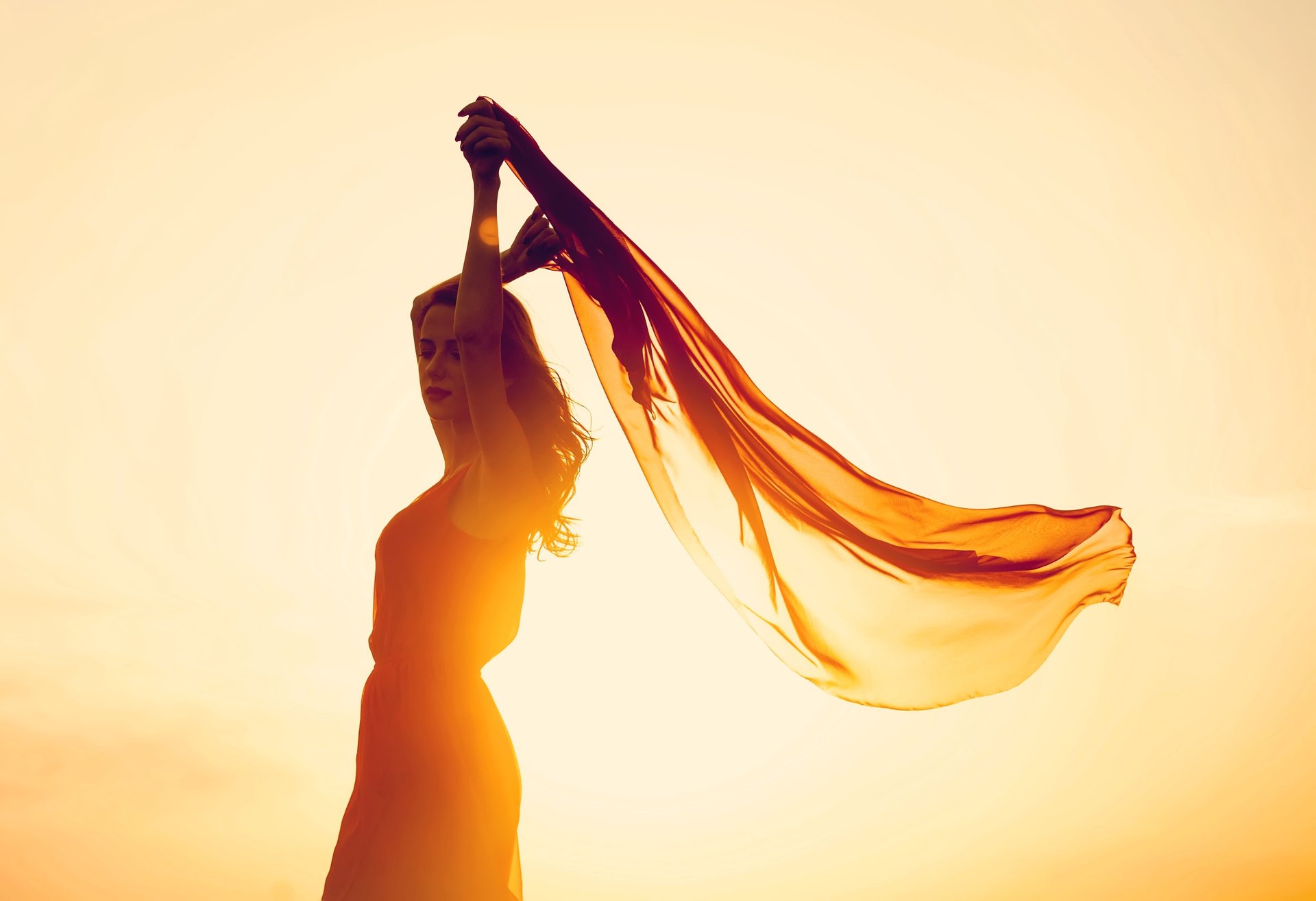 woman wearing yellow long-sleeved dress under white clouds and blue sky during daytime