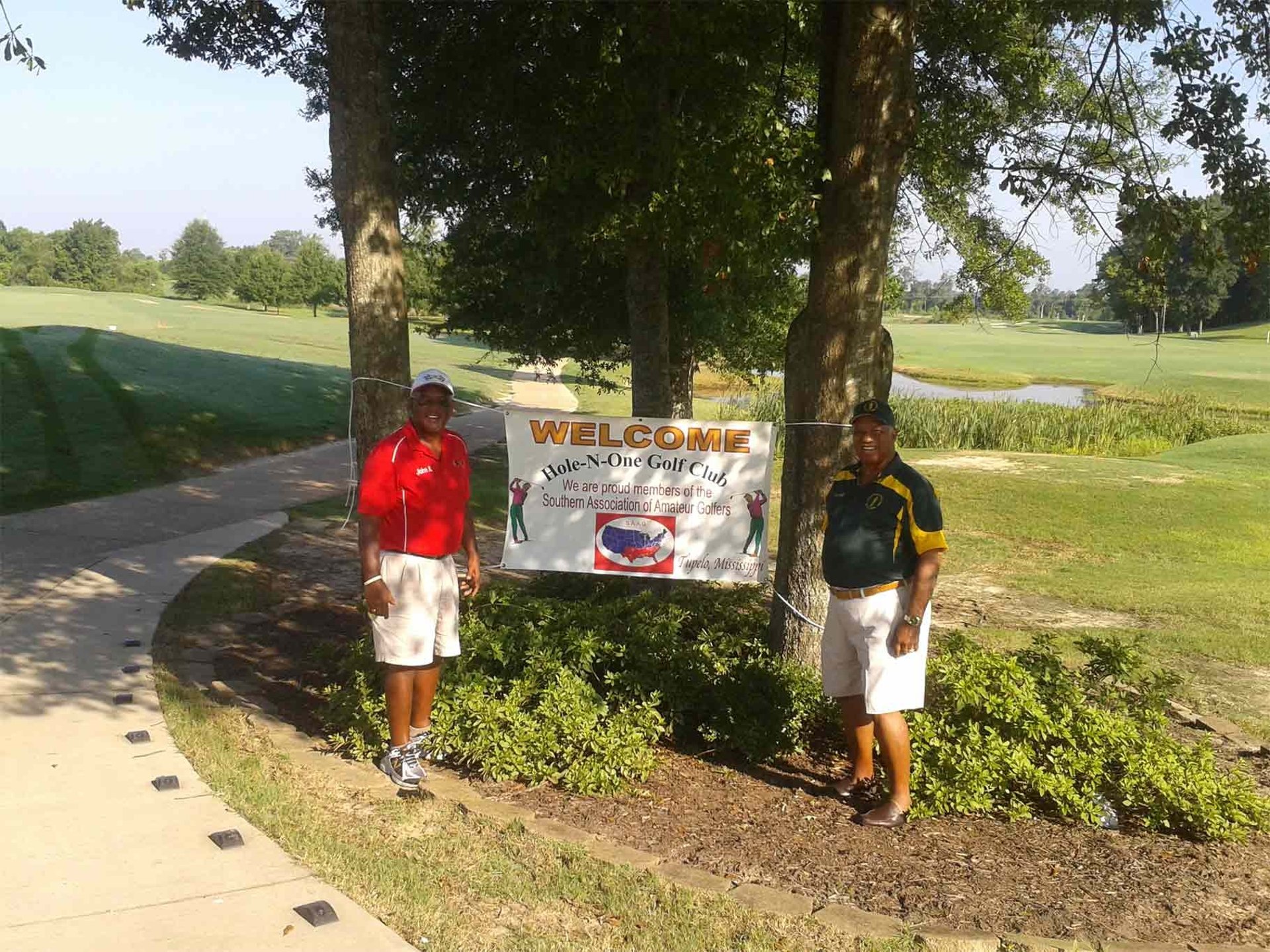SAAG image of Hole-N-One to members by a sign