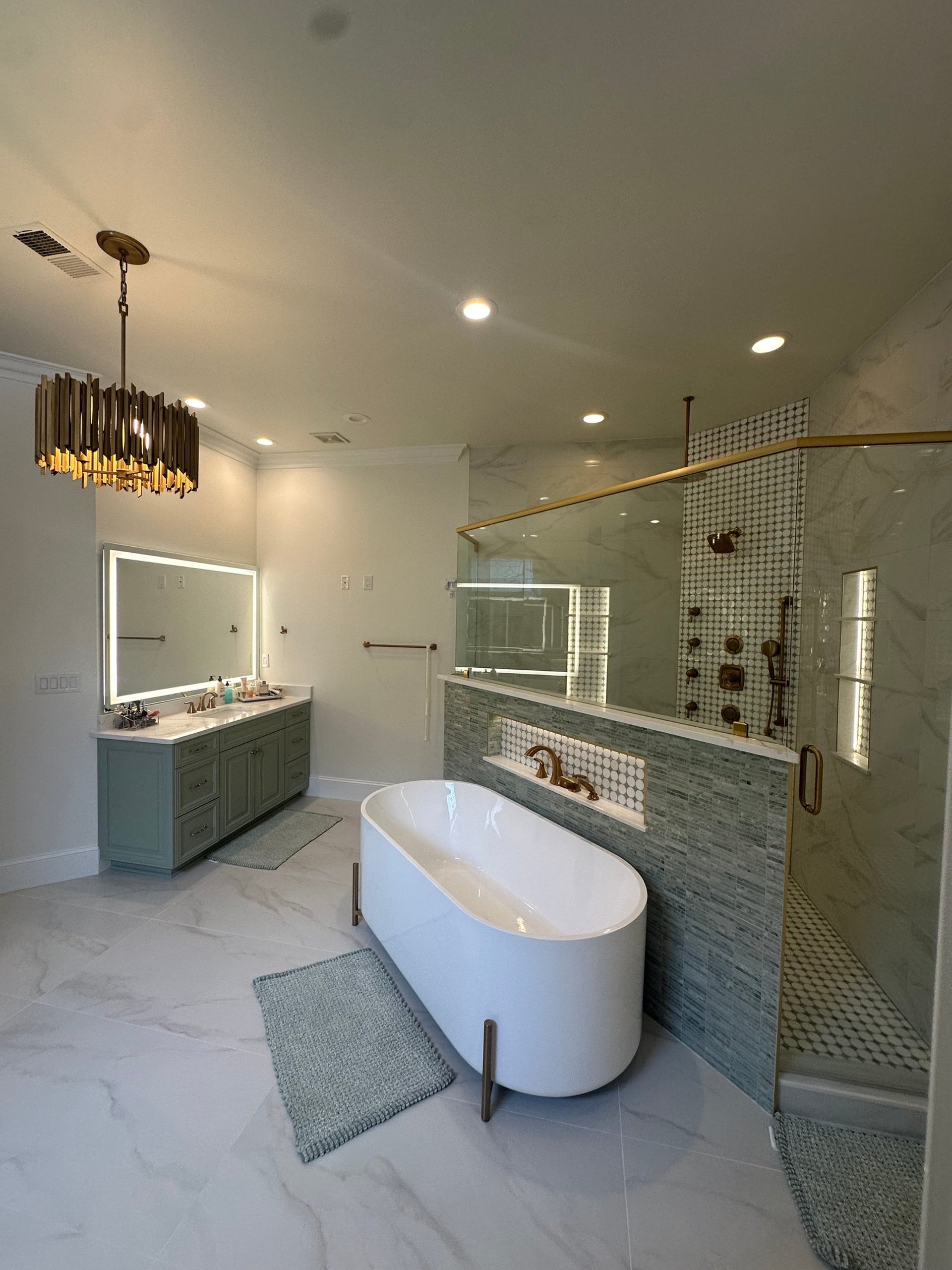 a bathroom with green cabinets and a marble shower
