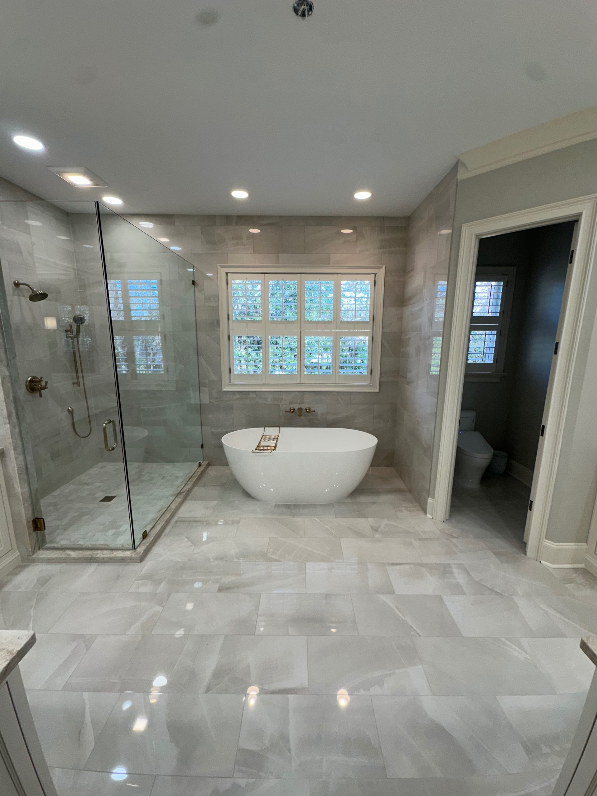 a bathroom with green cabinets and a marble shower