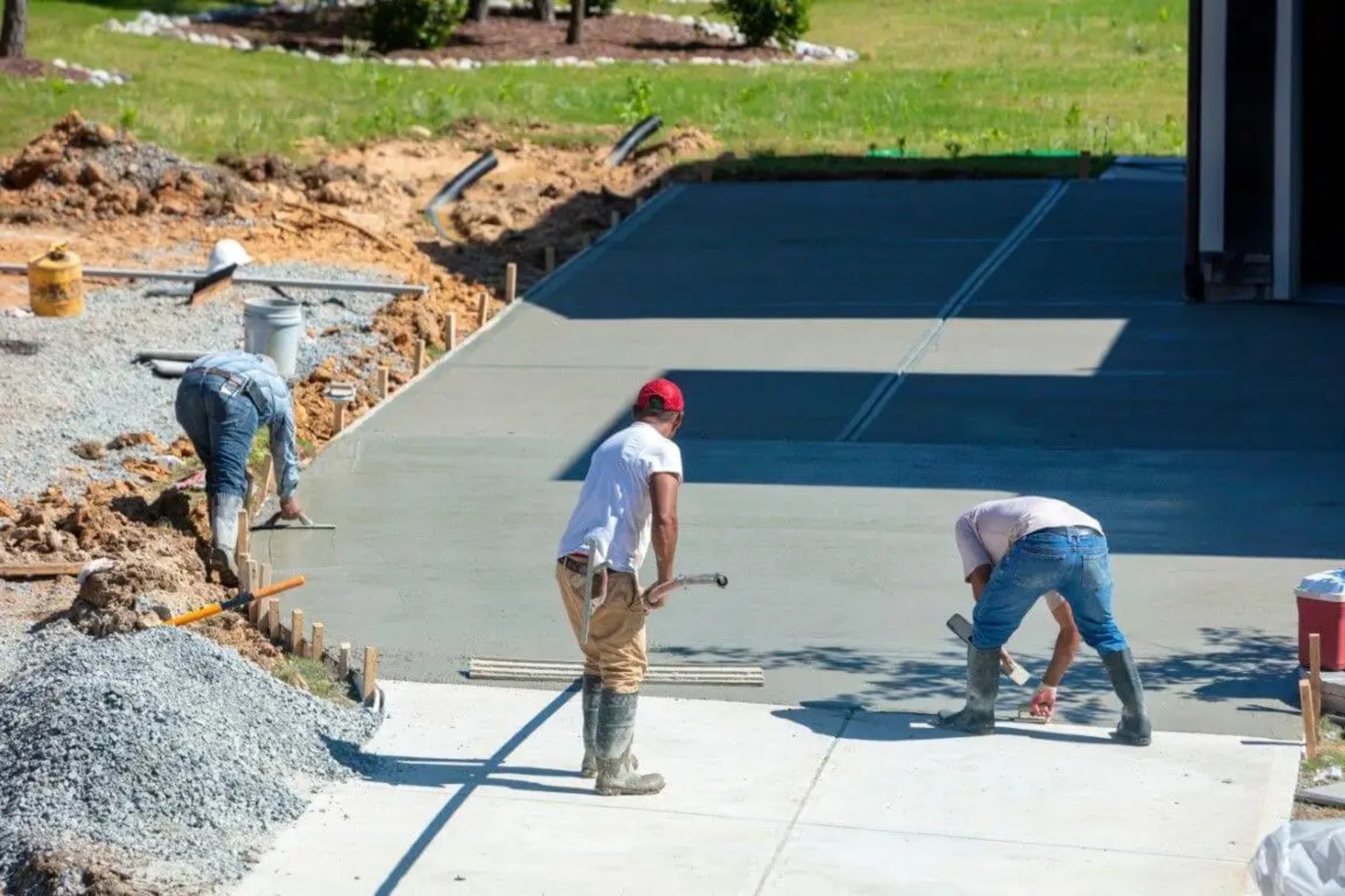 Men working on a freshly poured concrete driveway