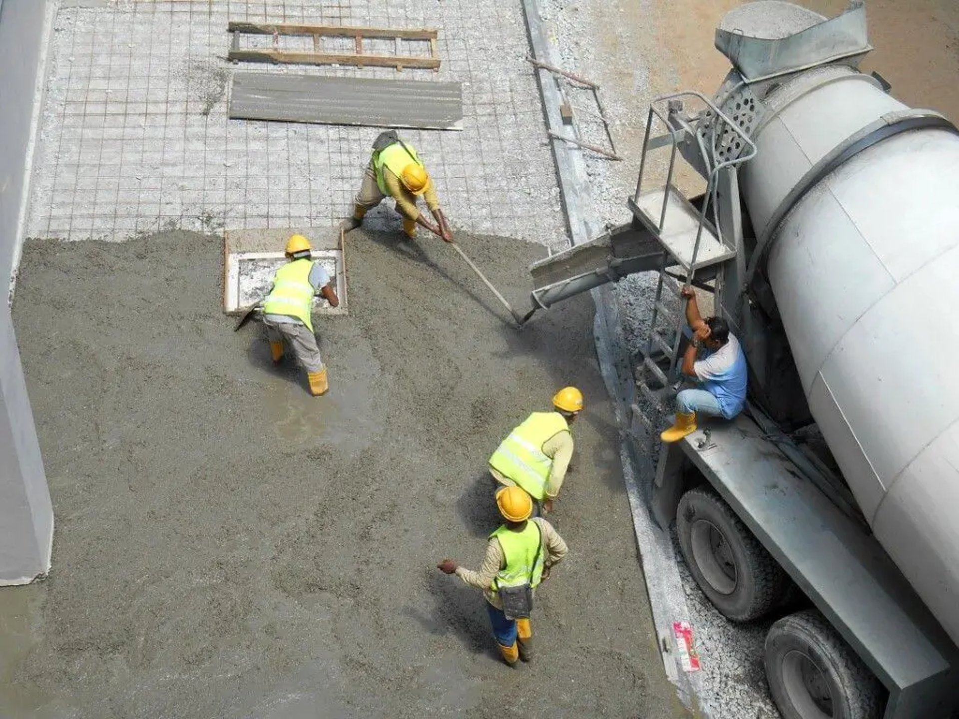 Men pouring and leveling fresh concrete 