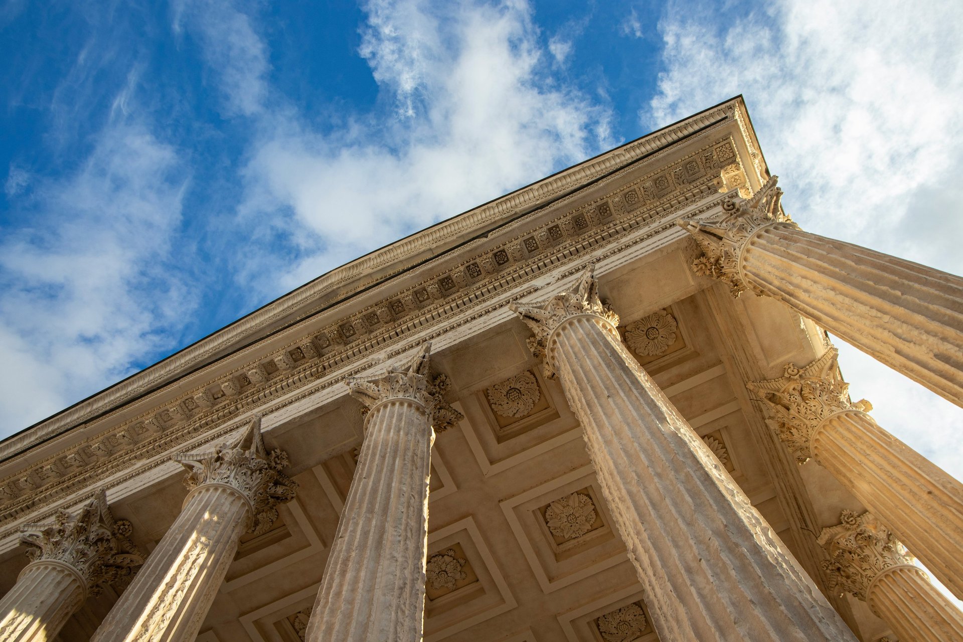 a large stone building with columns and a sky background