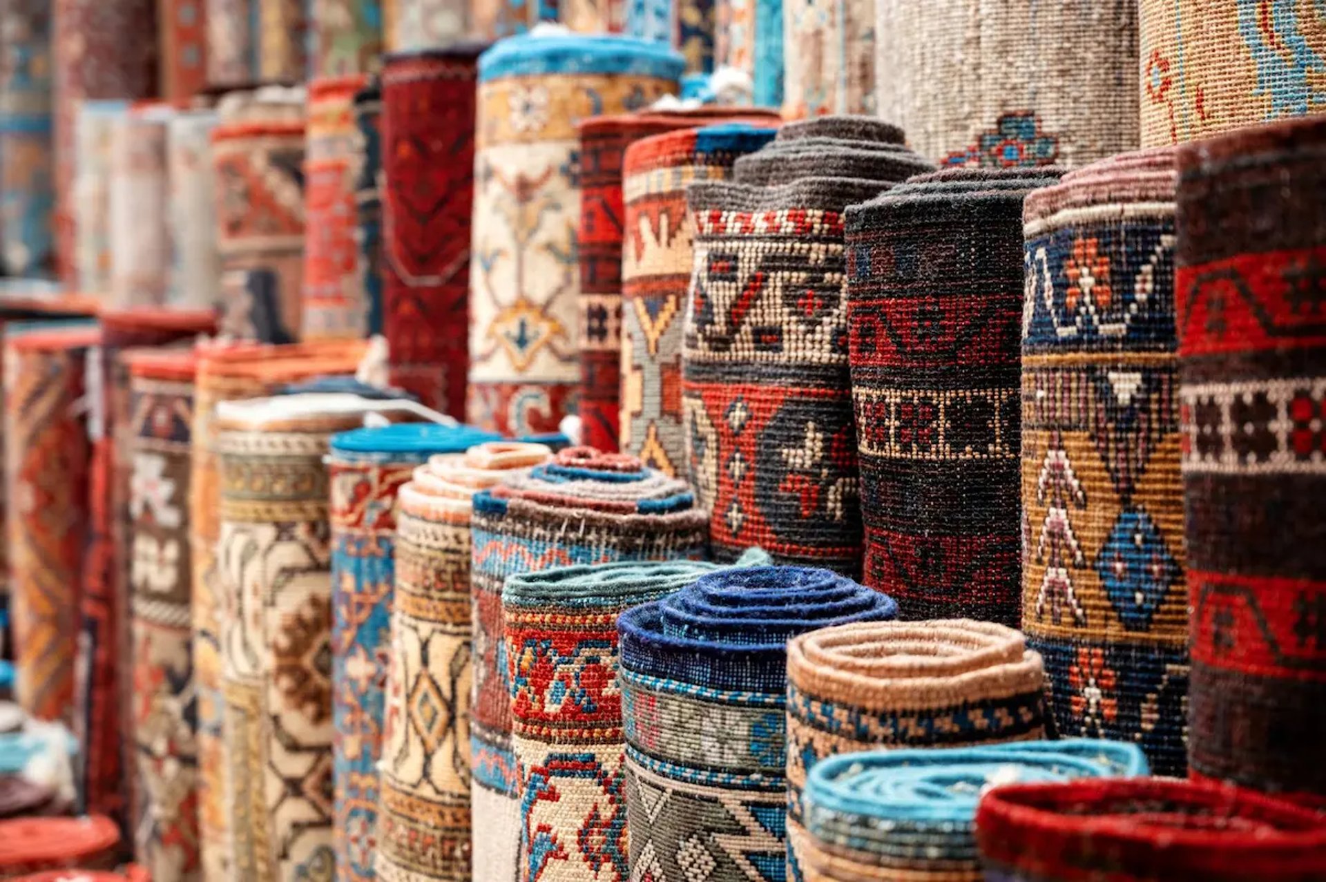 Rolled handwoven traditional Indian carpets in a Bhadohi manufacturing facility ready for global wholesale export.