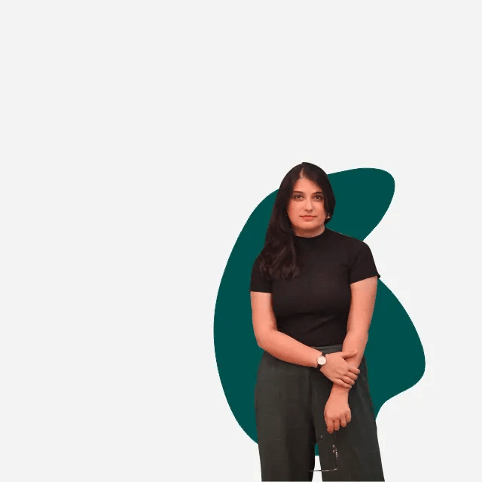 Pessoa de braços cruzados, segurando óculos, usando blusa preta de manga curta, em frente a formas abstratas verdes.
