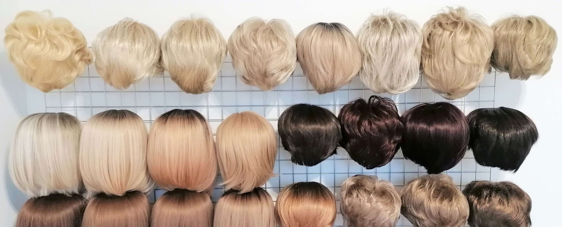 Įvairūs perukai, skirtingų stilių ir spalvų, siūlomi moterims po chemoterapijos.