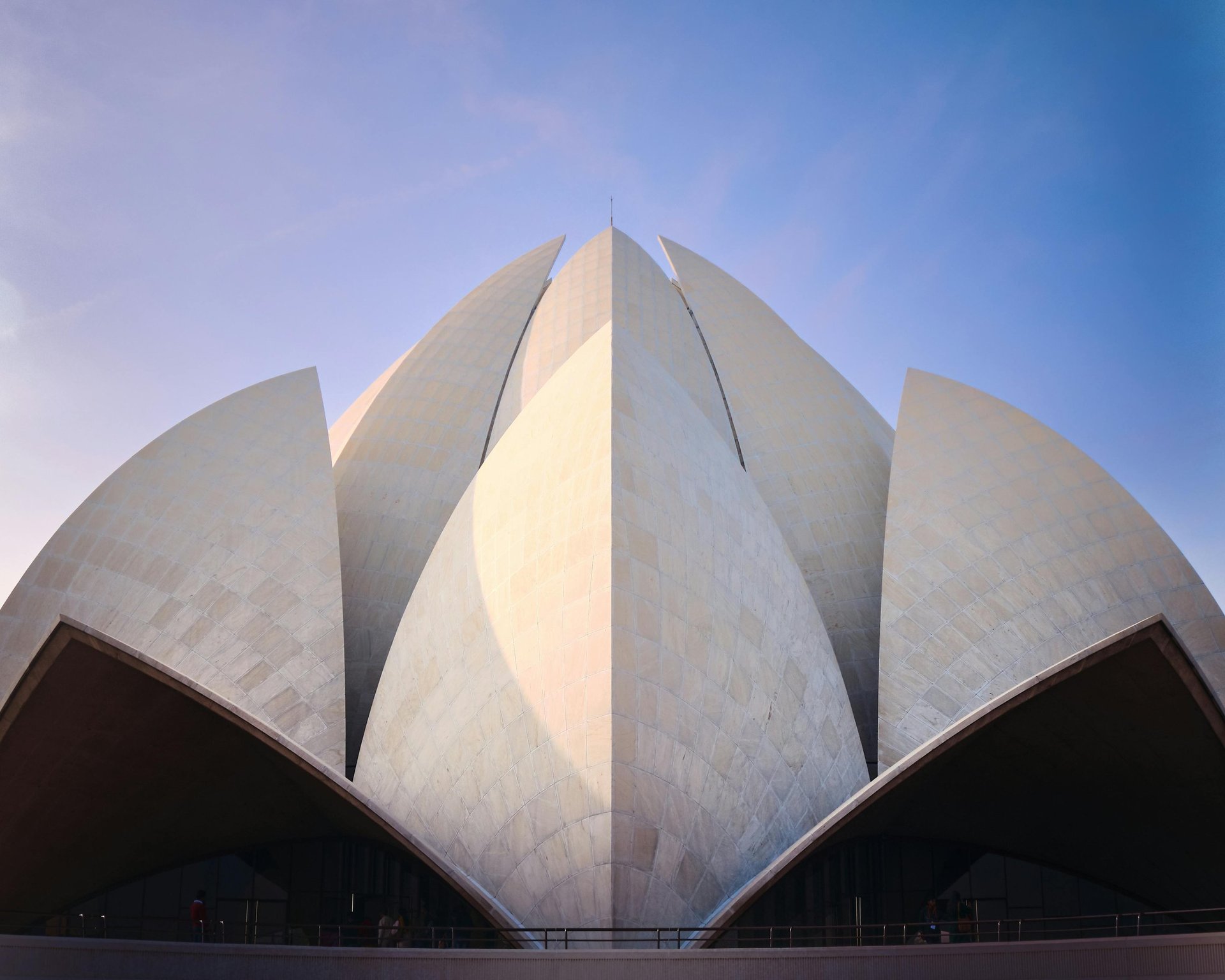 an abstract photo of a curved building with a blue sky in the background