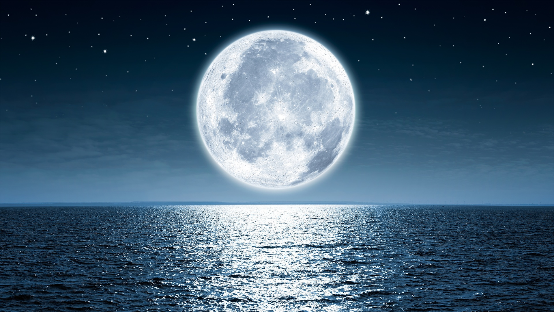 A full moon seen through the clouds in the night sky