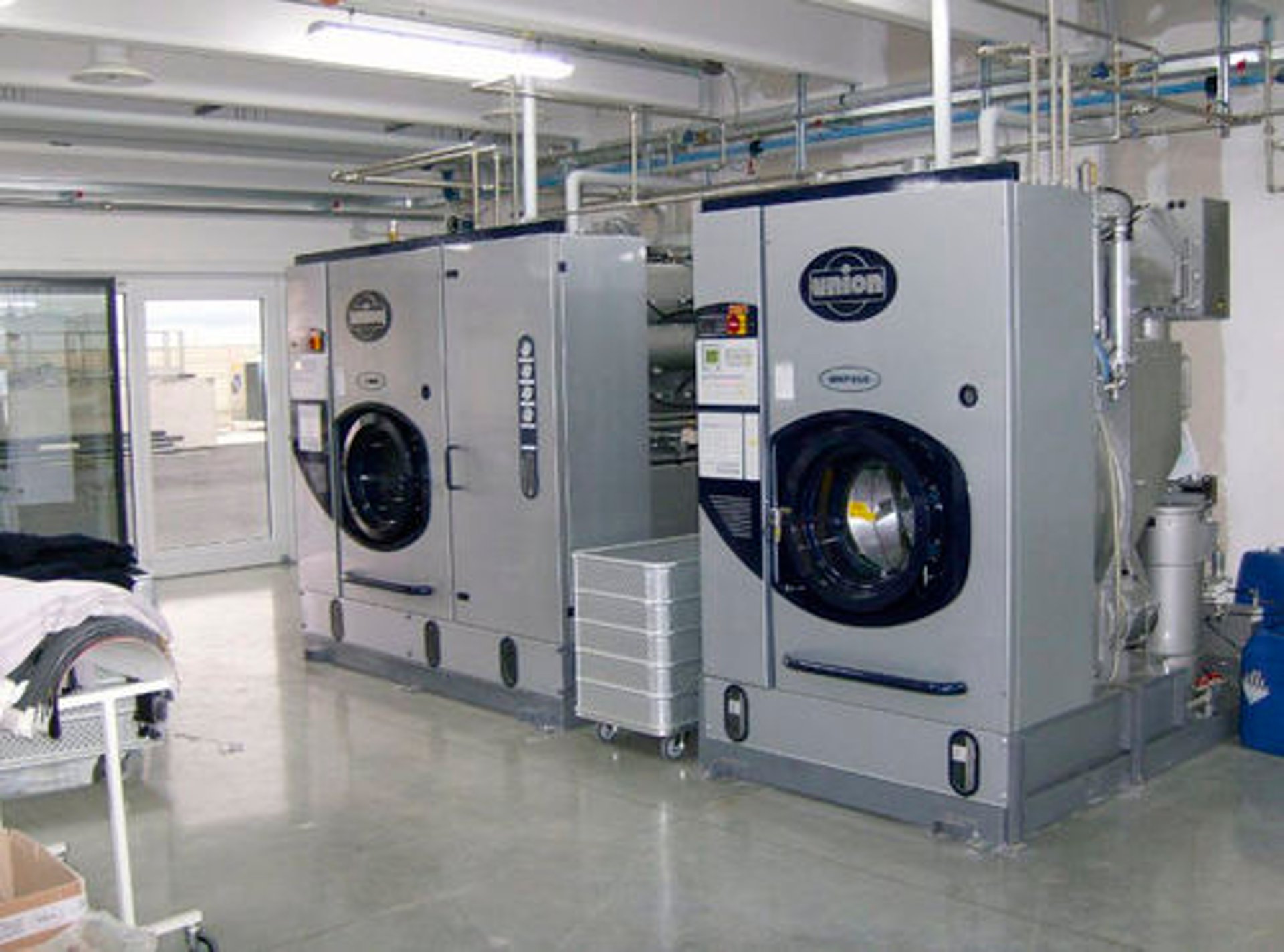 a row of washers and dryers in a laundry room