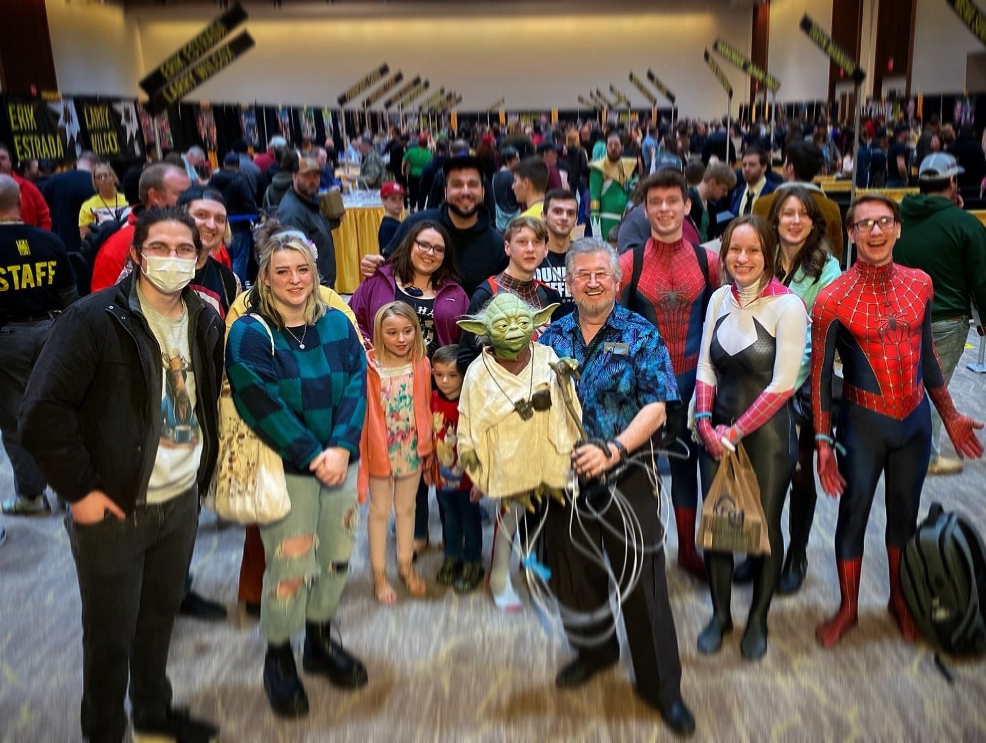 Young woman holding trash bag with volunteers cleaning beach