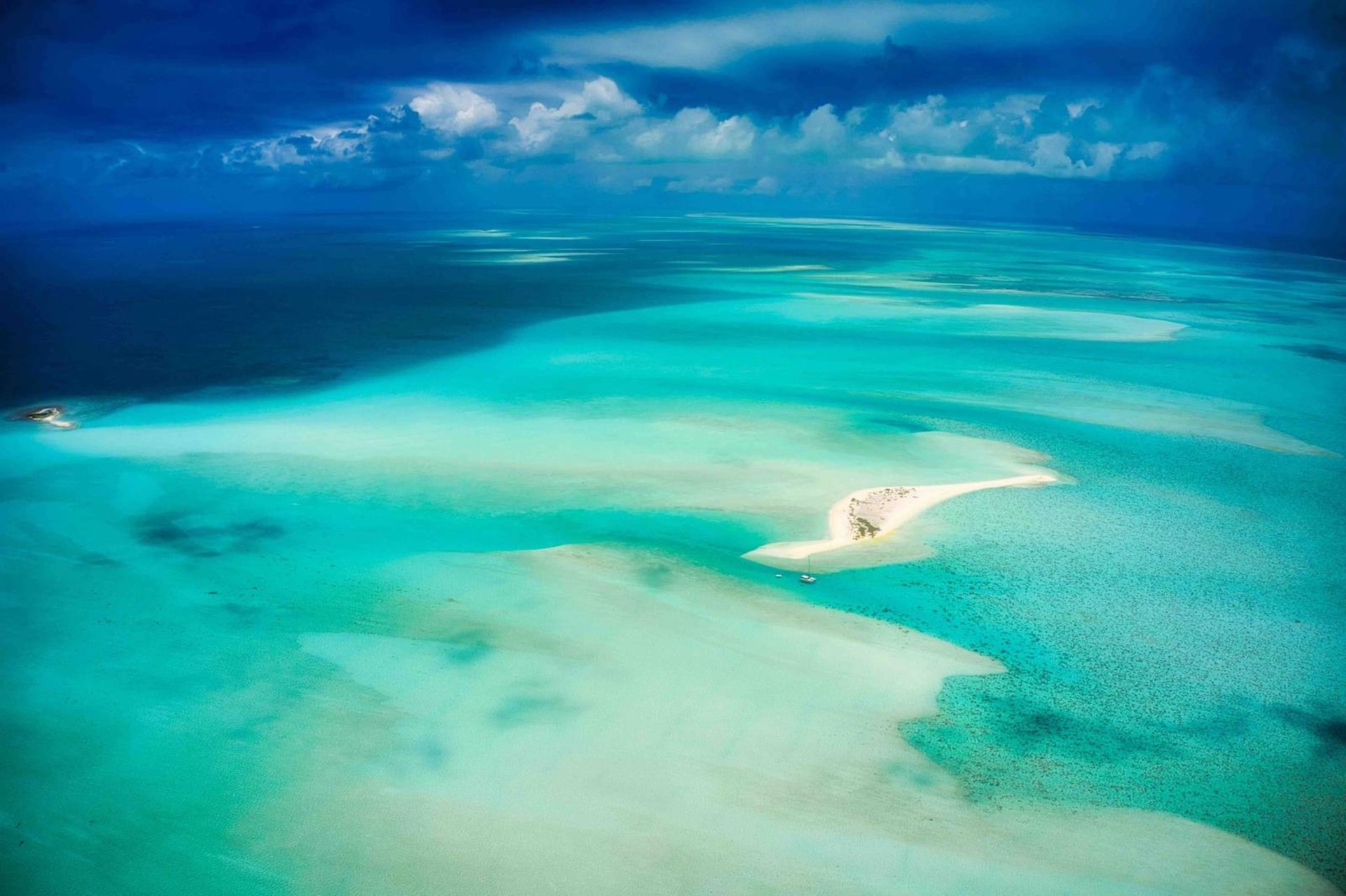 an aerial view of a beach with clear blue water