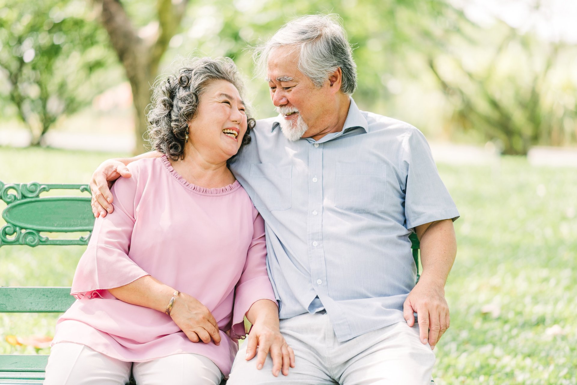 two people sitting on pavement facing on body of water