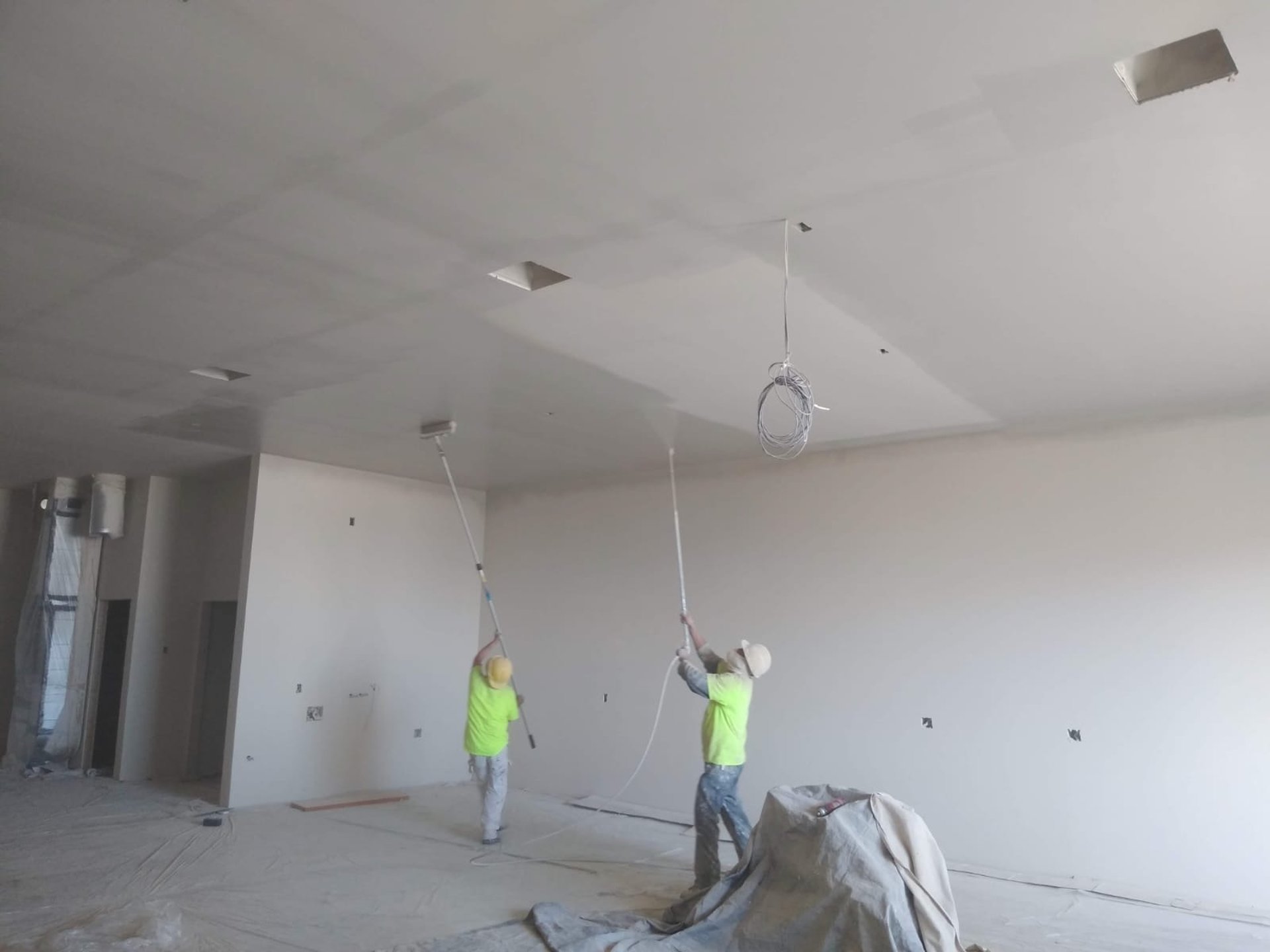 a man painting a wall with a paint roller