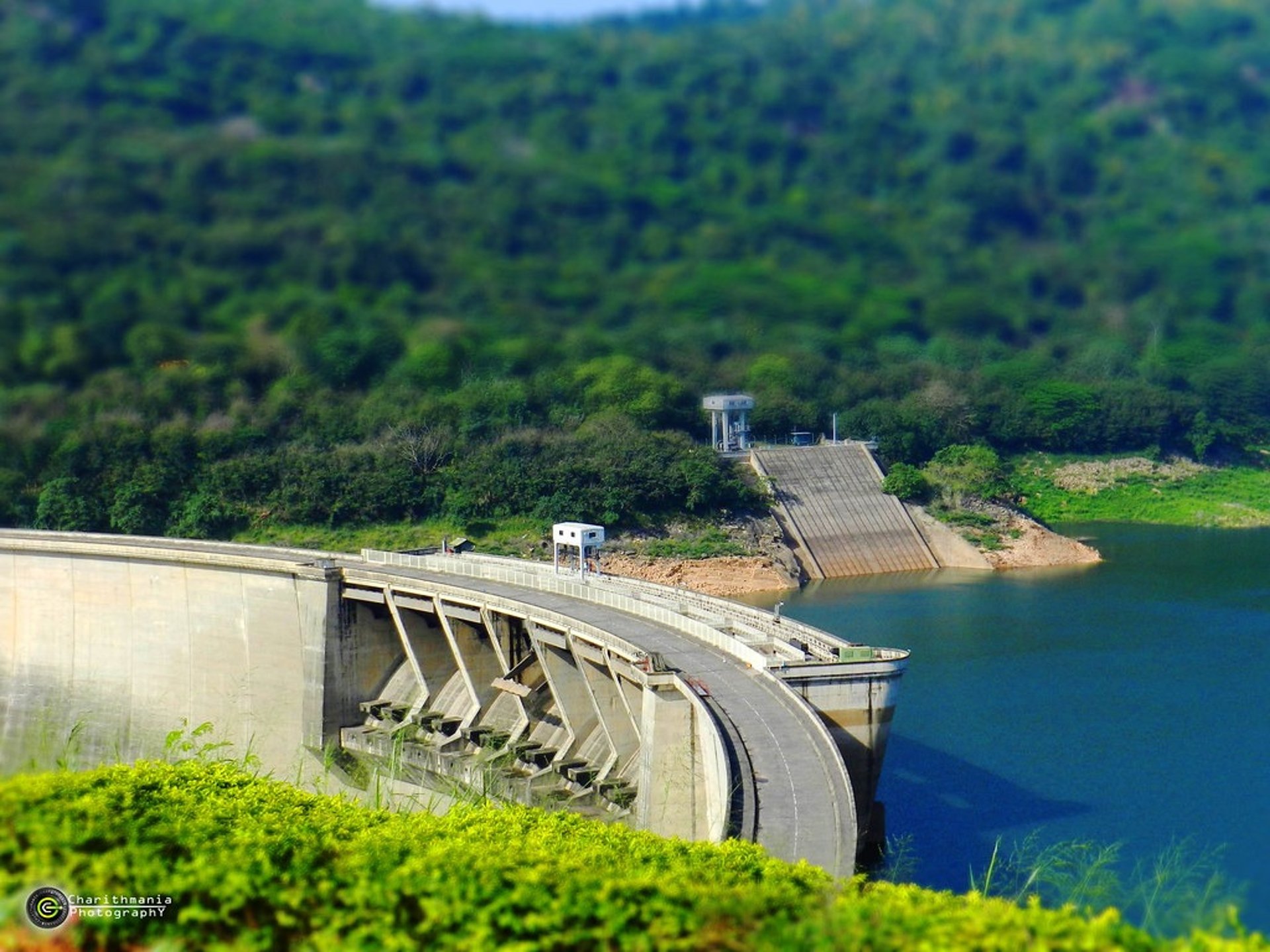 photo of concrete dam in lake near mountains during daytime