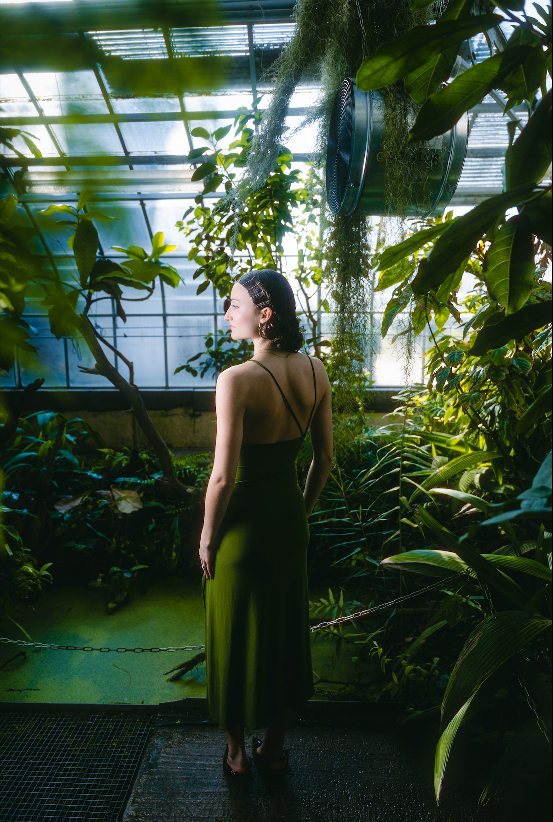 a woman wearing a white shirt and a fur hat holding a glass of wine