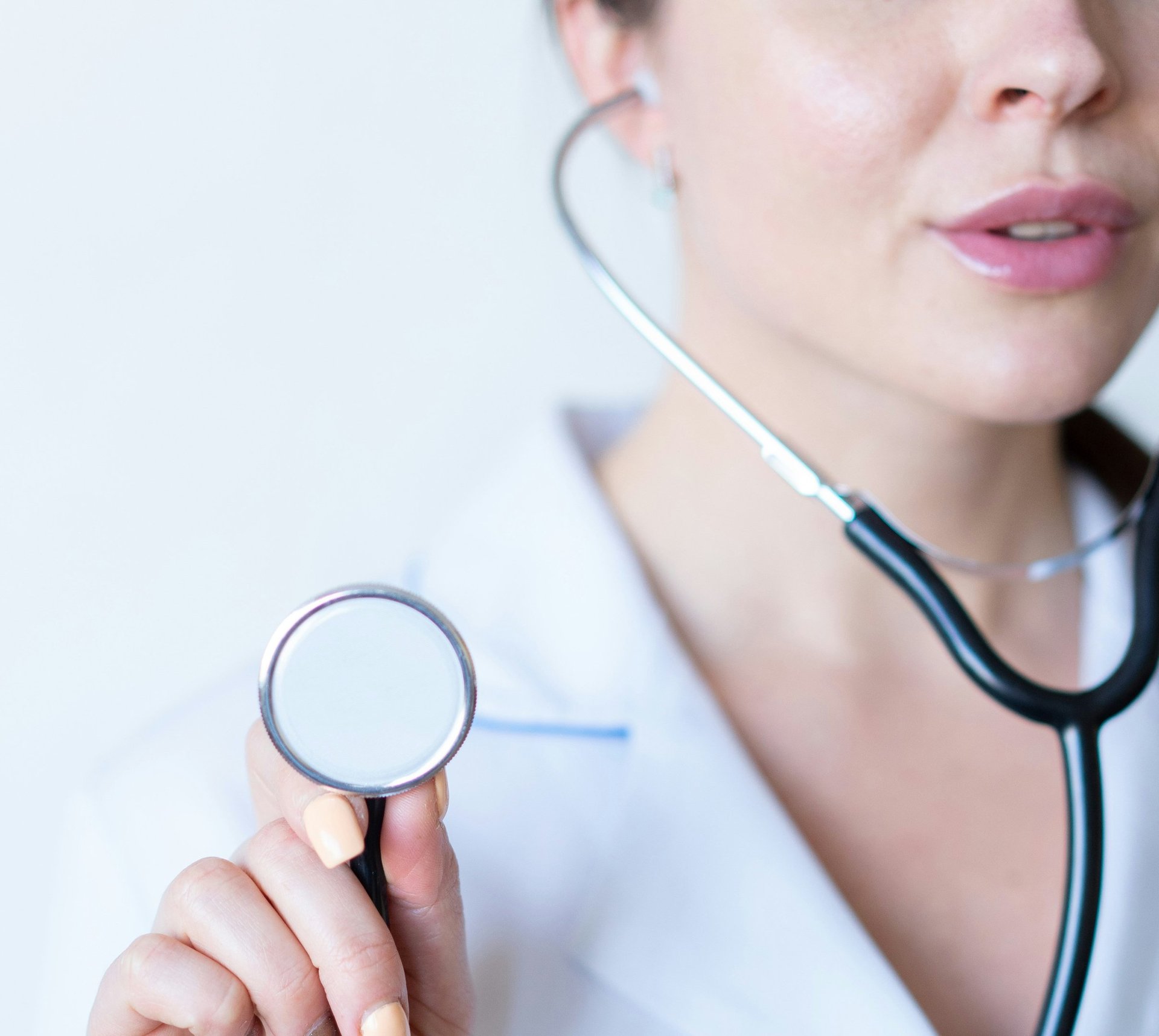 a woman in a white shirt holding a stethoscope
