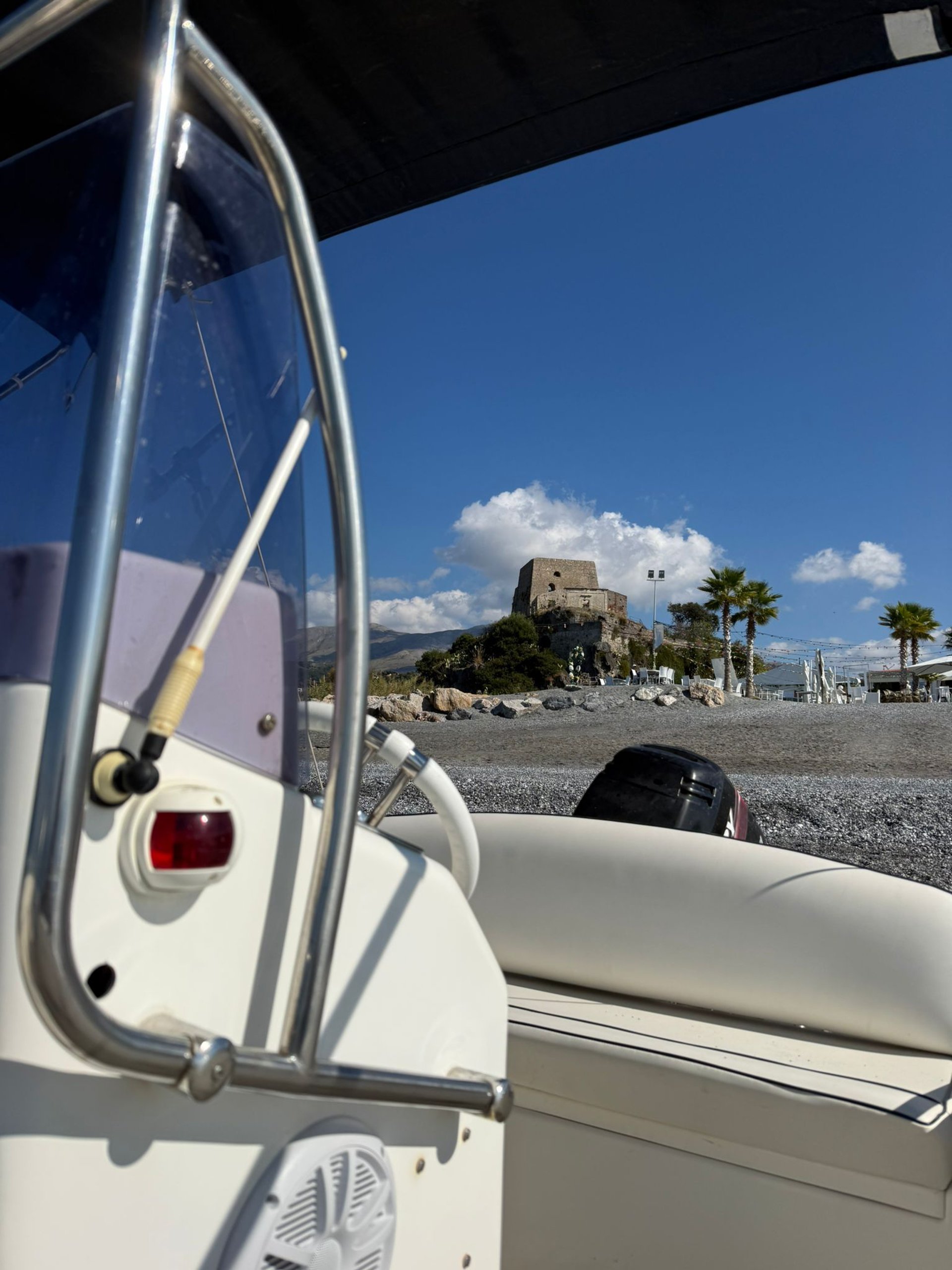 Buildings overlook the sea with a tower in the background.