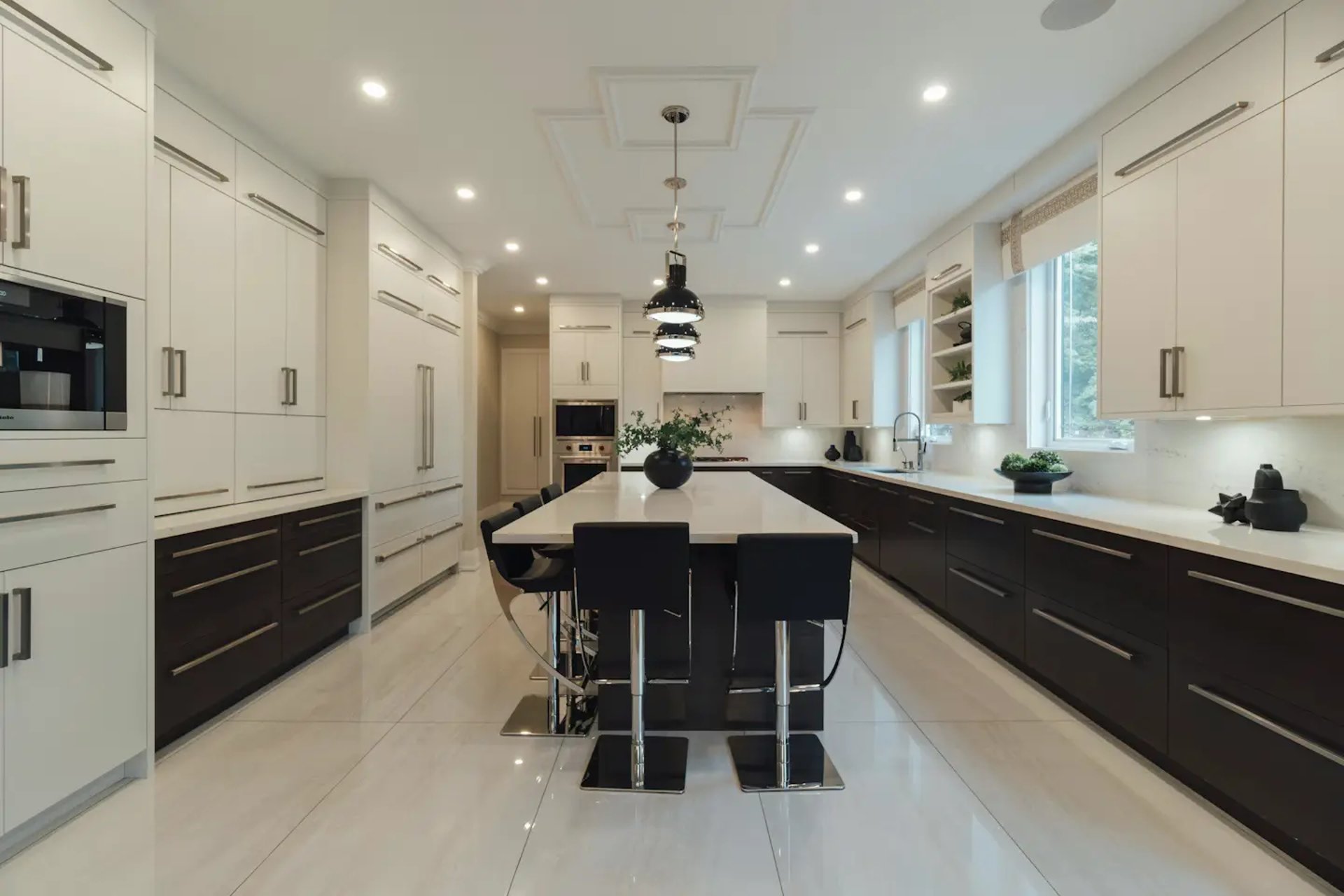 a large kitchen with a center island and white cabinets