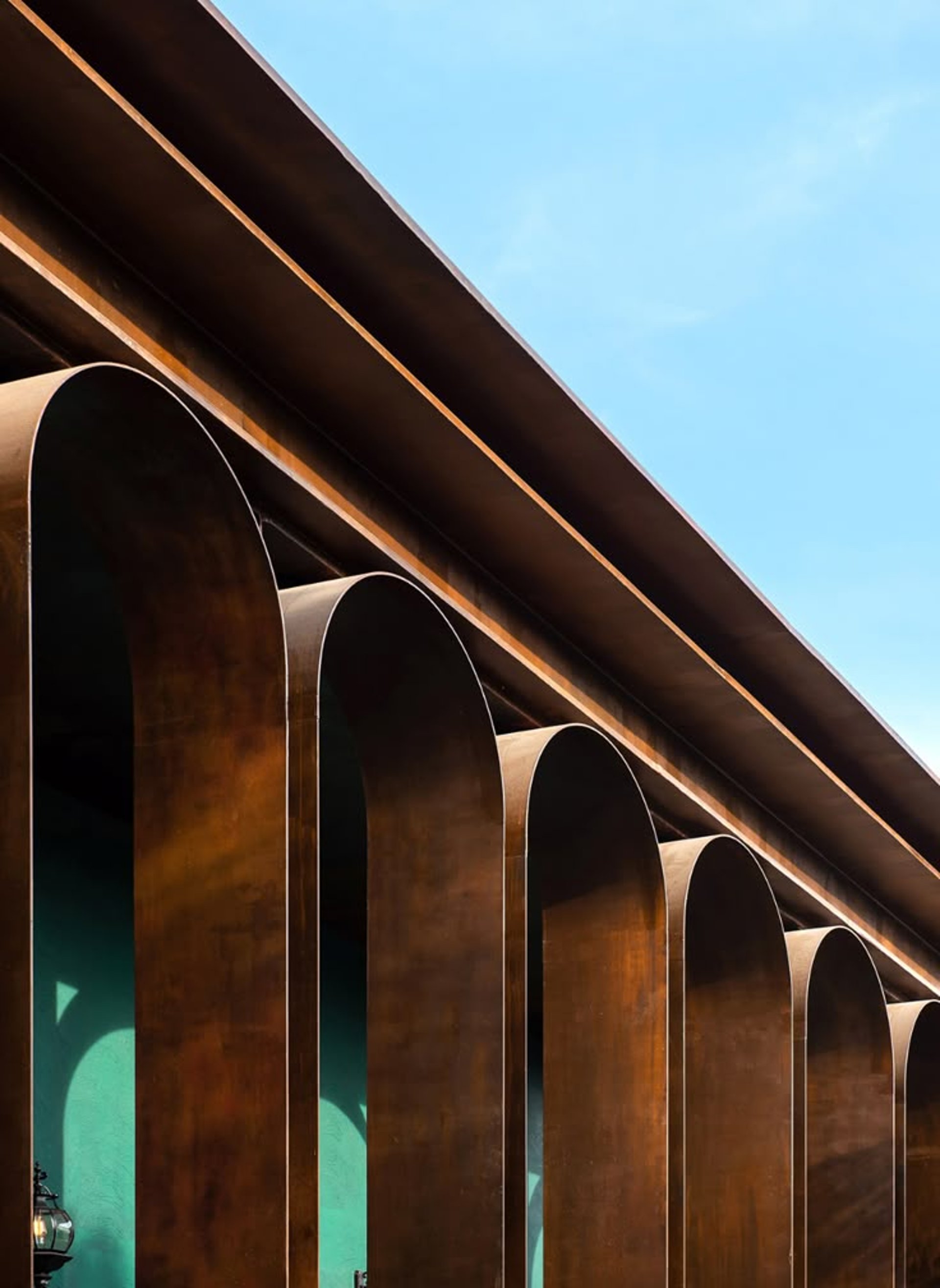 an abstract photo of a curved building with a blue sky in the background