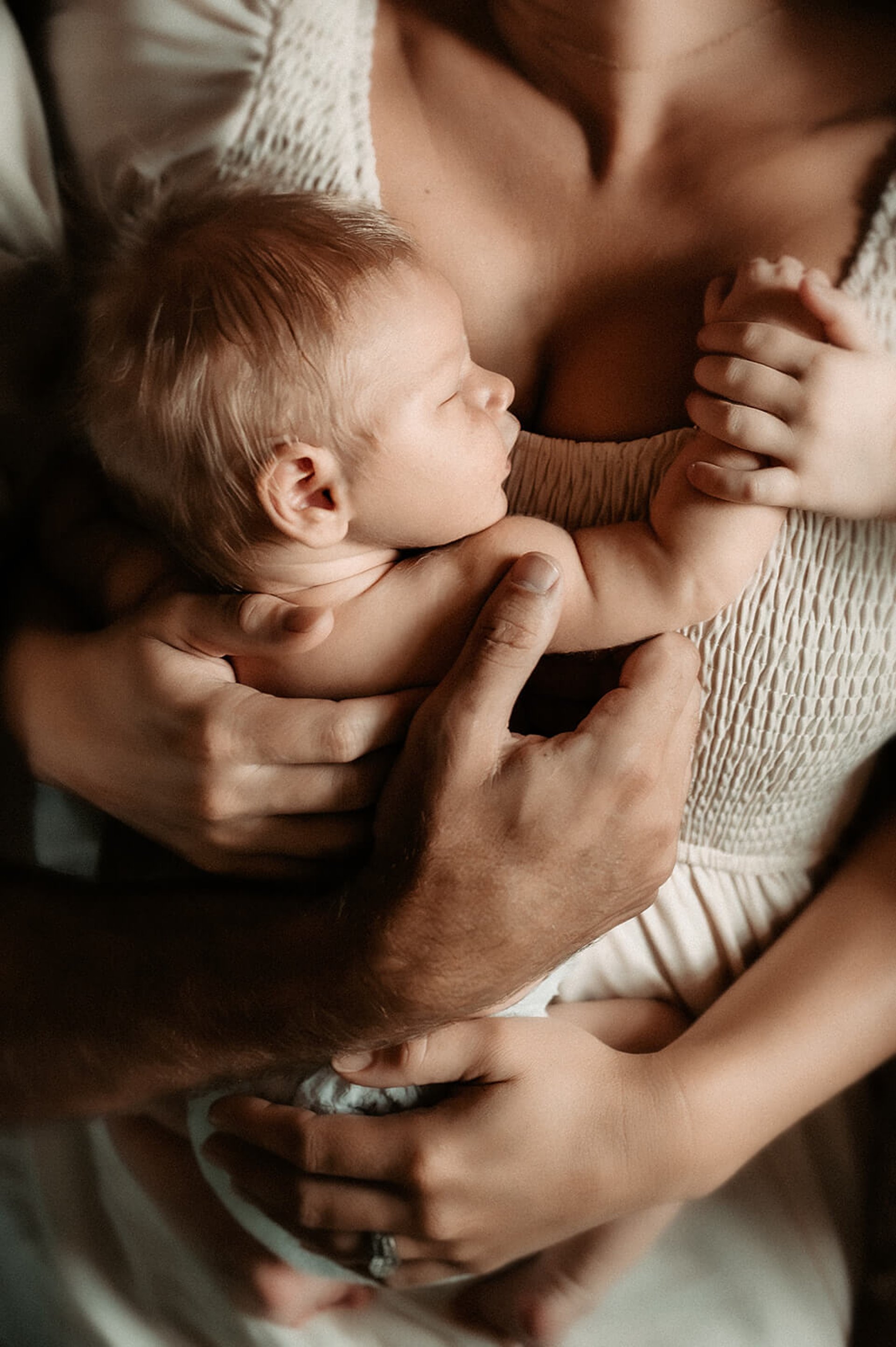 Newborn baby in mama’s arms during a Duluth MN in-home session