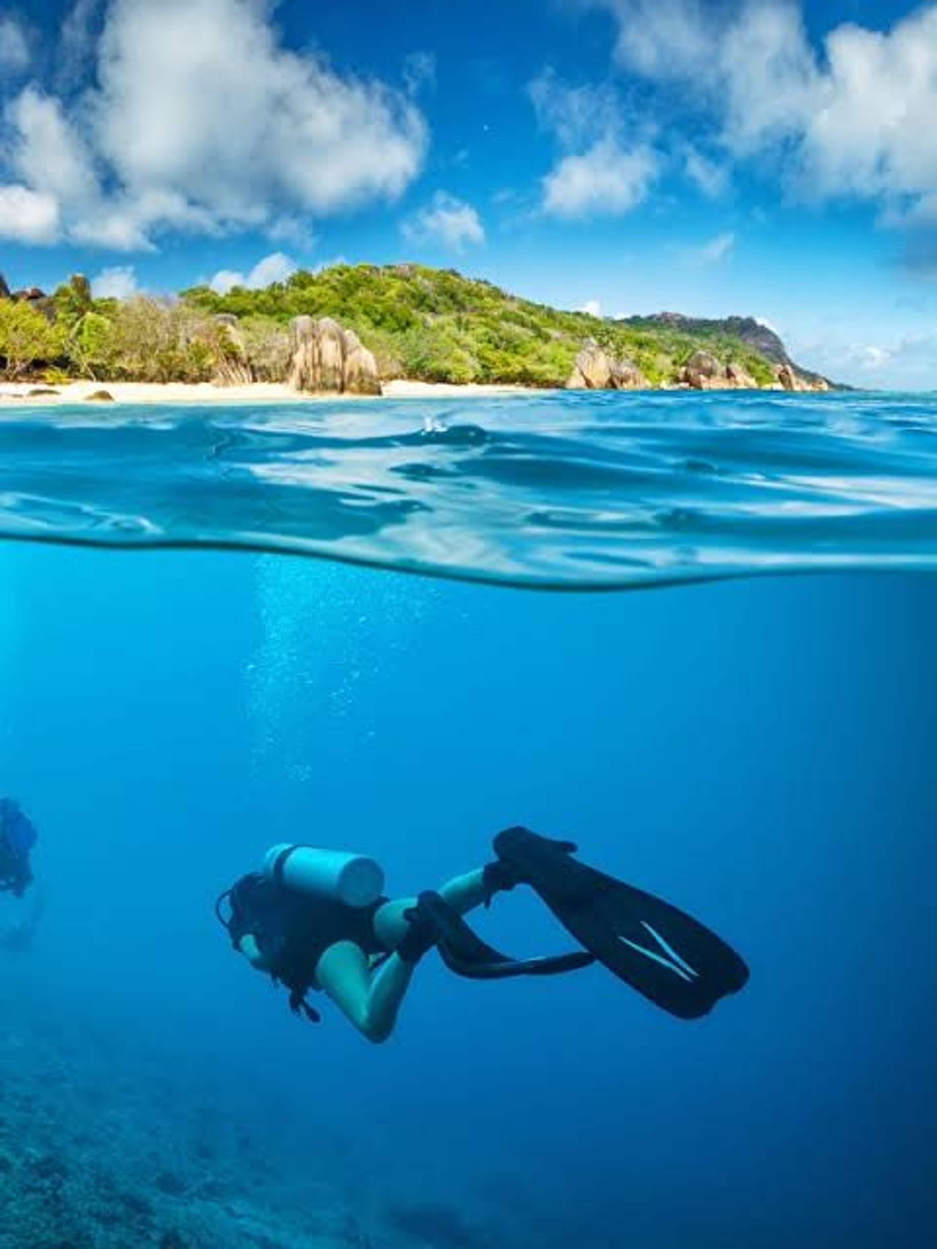 two people diving on clear body of water