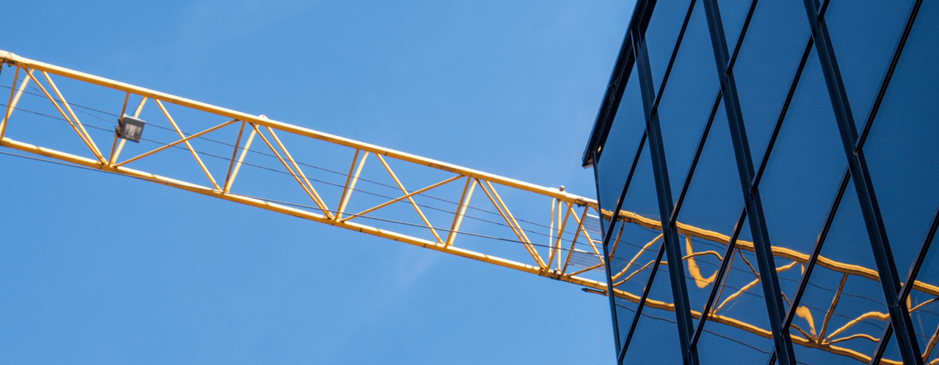 man in yellow shirt and blue denim jeans jumping on brown wooden railings under blue and