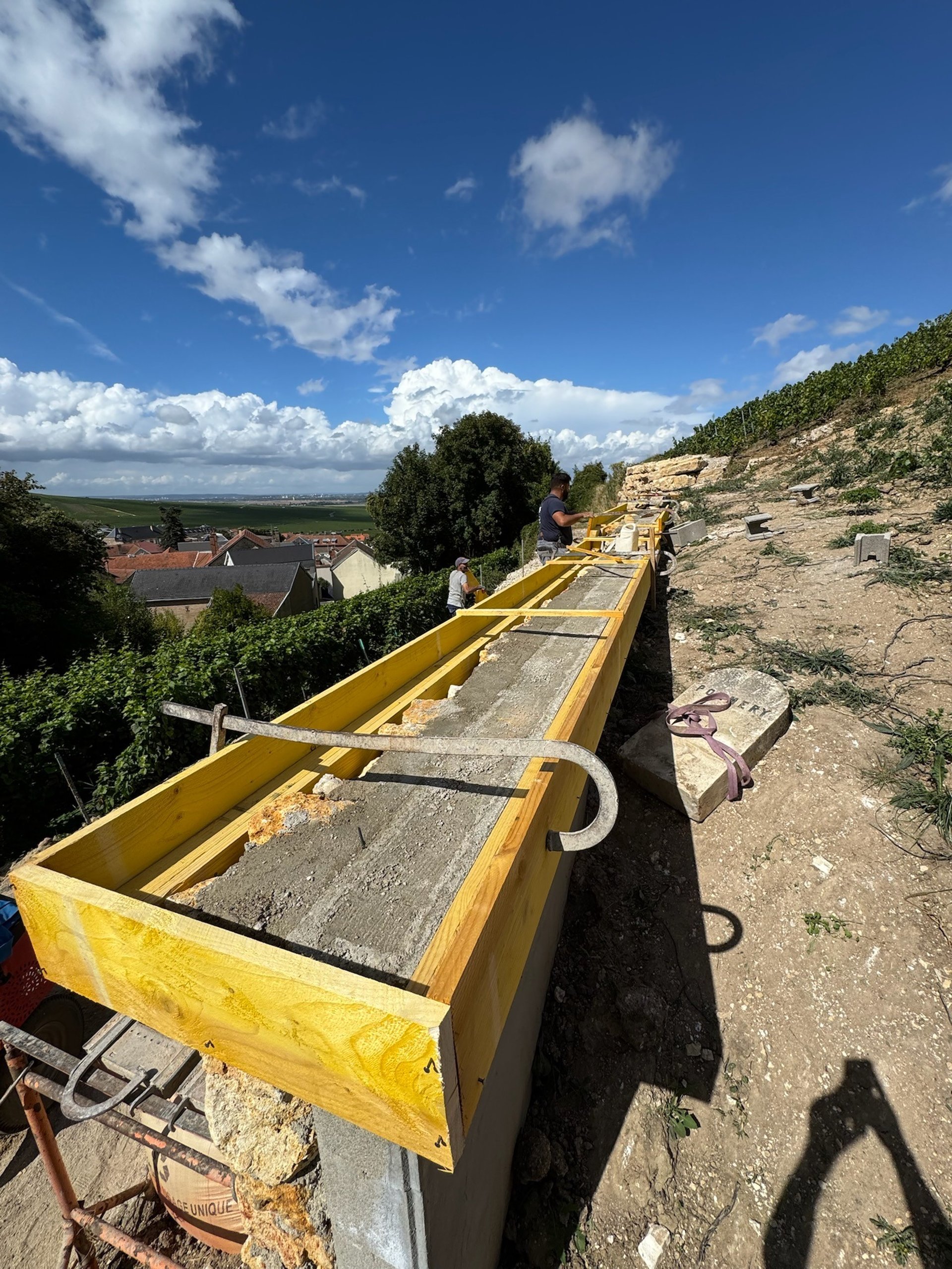 man in yellow shirt and blue denim jeans jumping on brown wooden railings under blue and