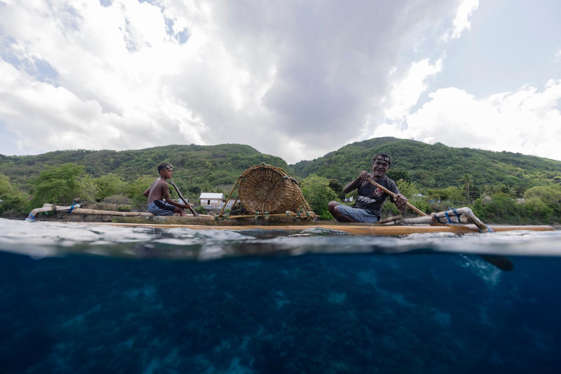 a father and son preparing to place a fish trap on the reef in Alor, Indonesia