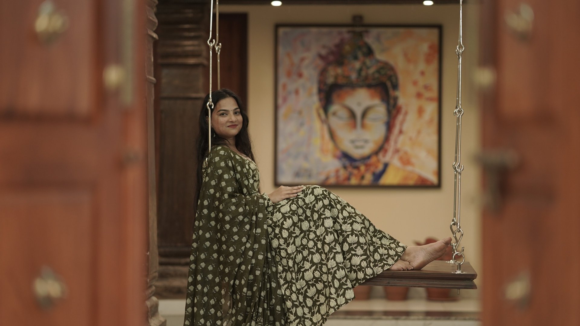 a woman wearing sunglasses standing in front of a window